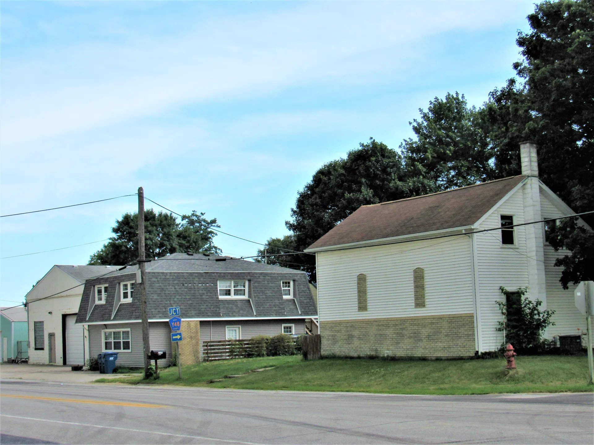 Historic white buildings on a quiet street in Maysville, Iowa.