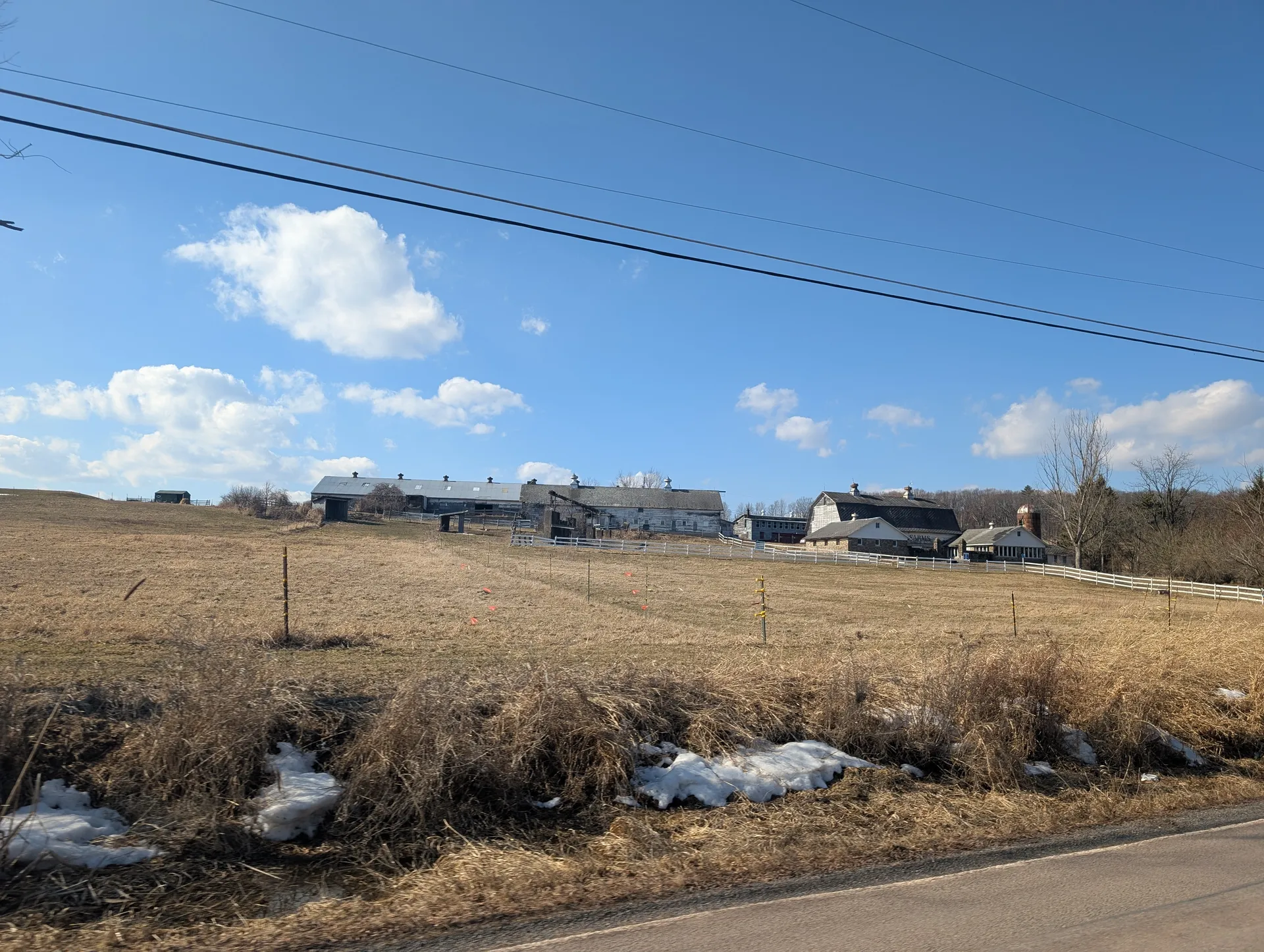 Farm fields and outbuildings spread across a rise in Glenburn Township under a bright spring sky.