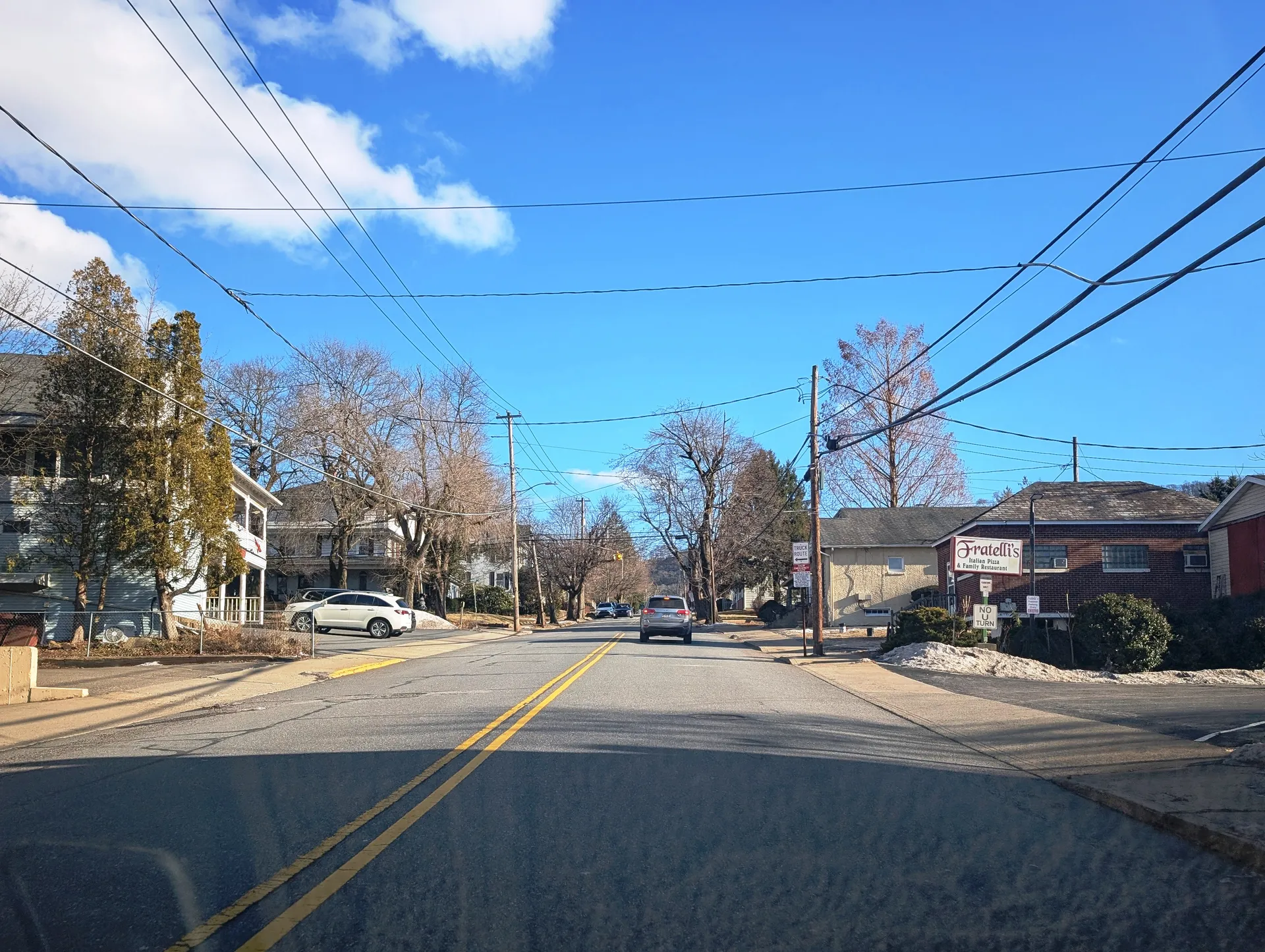 Main Street in Conyngham runs southeast between Sugarloaf and Butler avenues, passing older homes and bare trees on a bright day.
