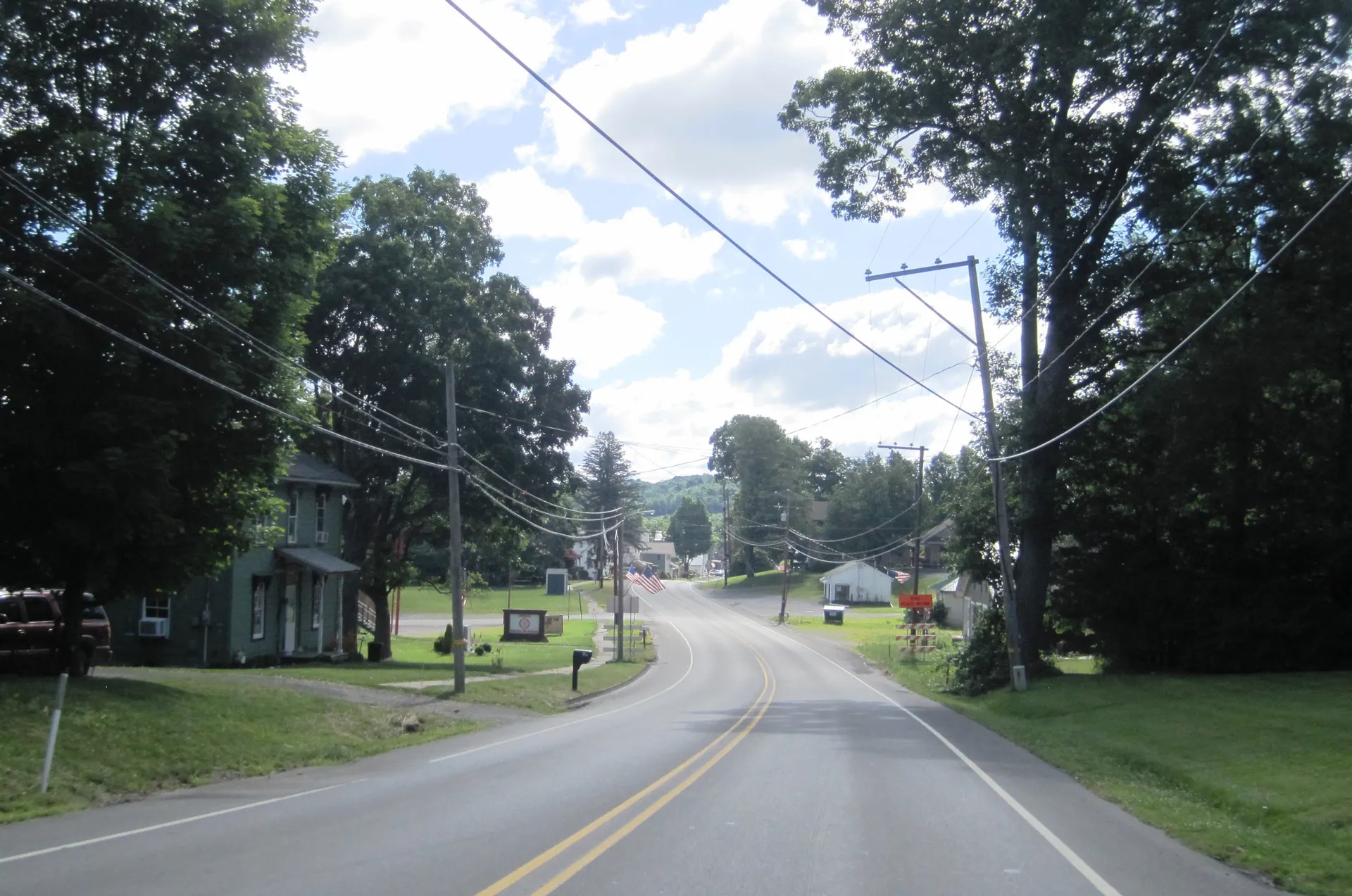 Main Street (U.S. Route 322) enters Corsica from the Clarion County line, passing houses, lawns and mature trees.