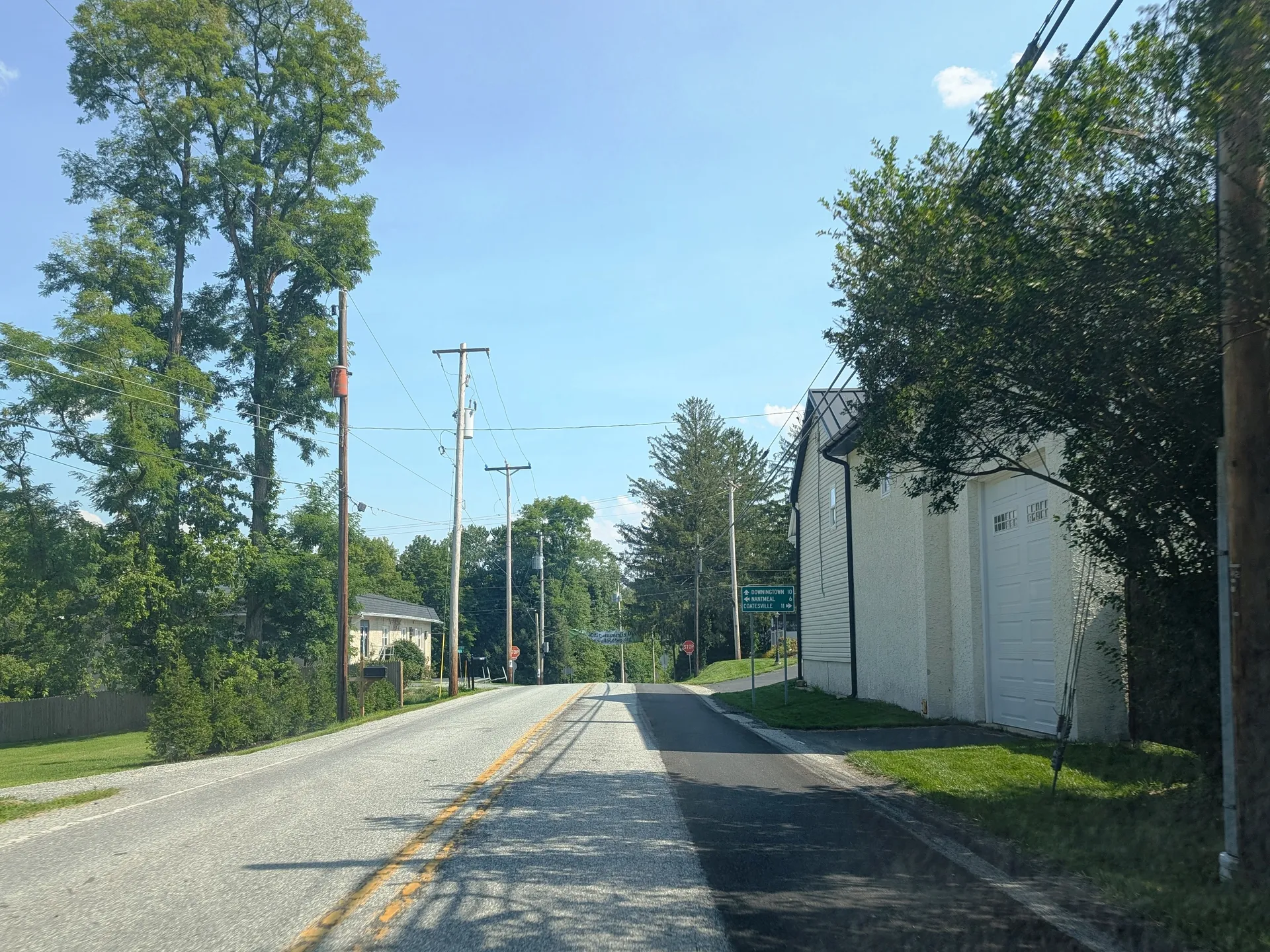 Creek Road (Route 282) passes through Glenmoore in Wallace Township, beside a white building and tall trees.