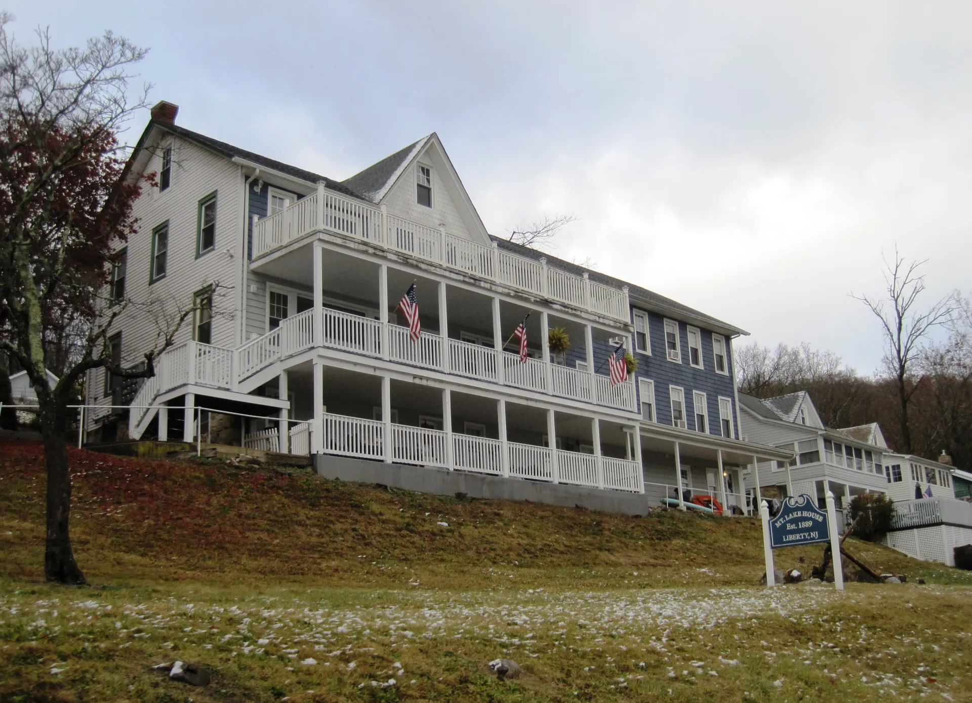 The Mountain Lake House is a large white three-story building with stacked porches overlooking a slope.