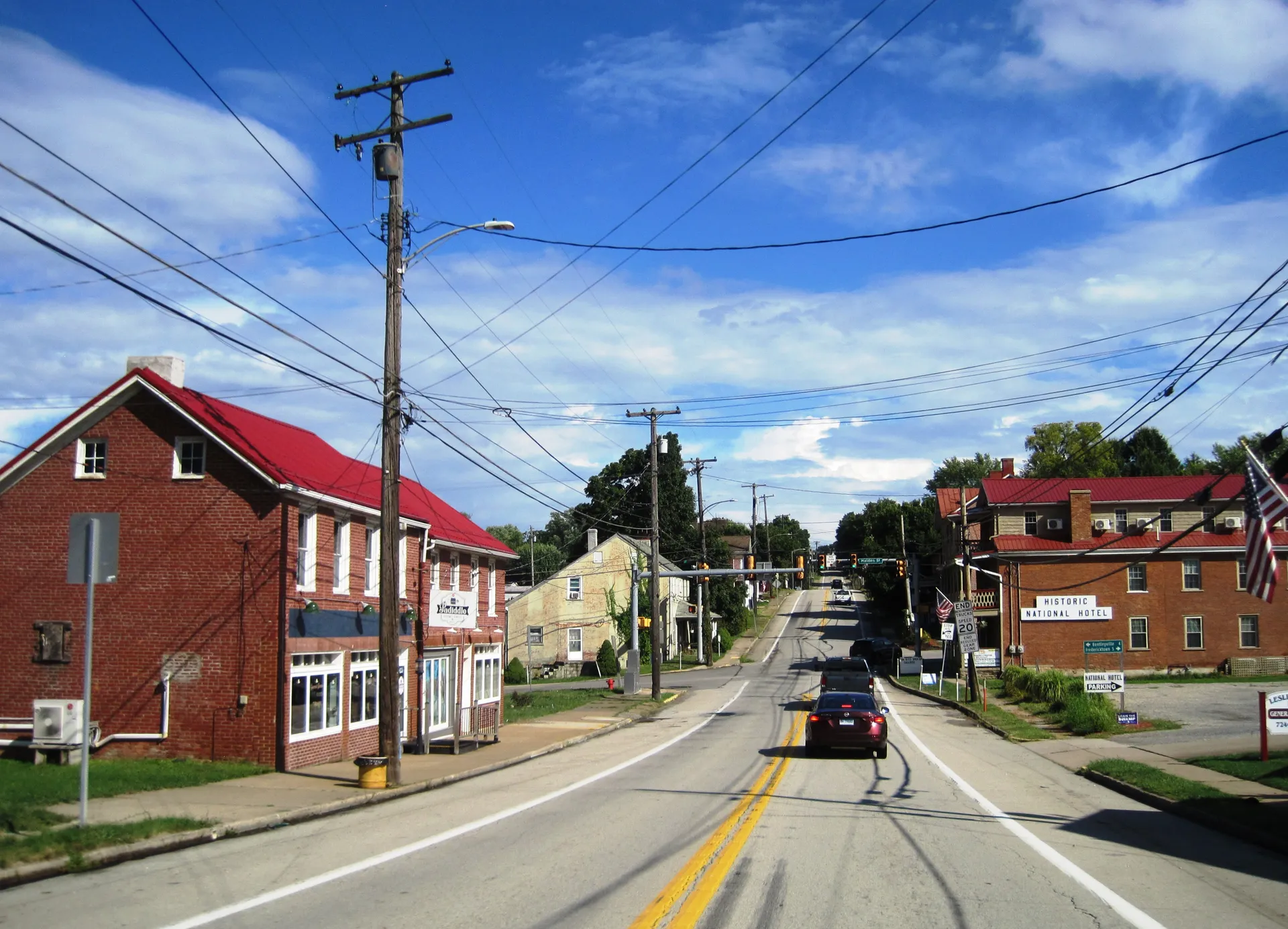 Main Street (U.S. Route 40) in Beallsville passes red-roofed brick storefronts and older homes between Locust and Maiden streets.