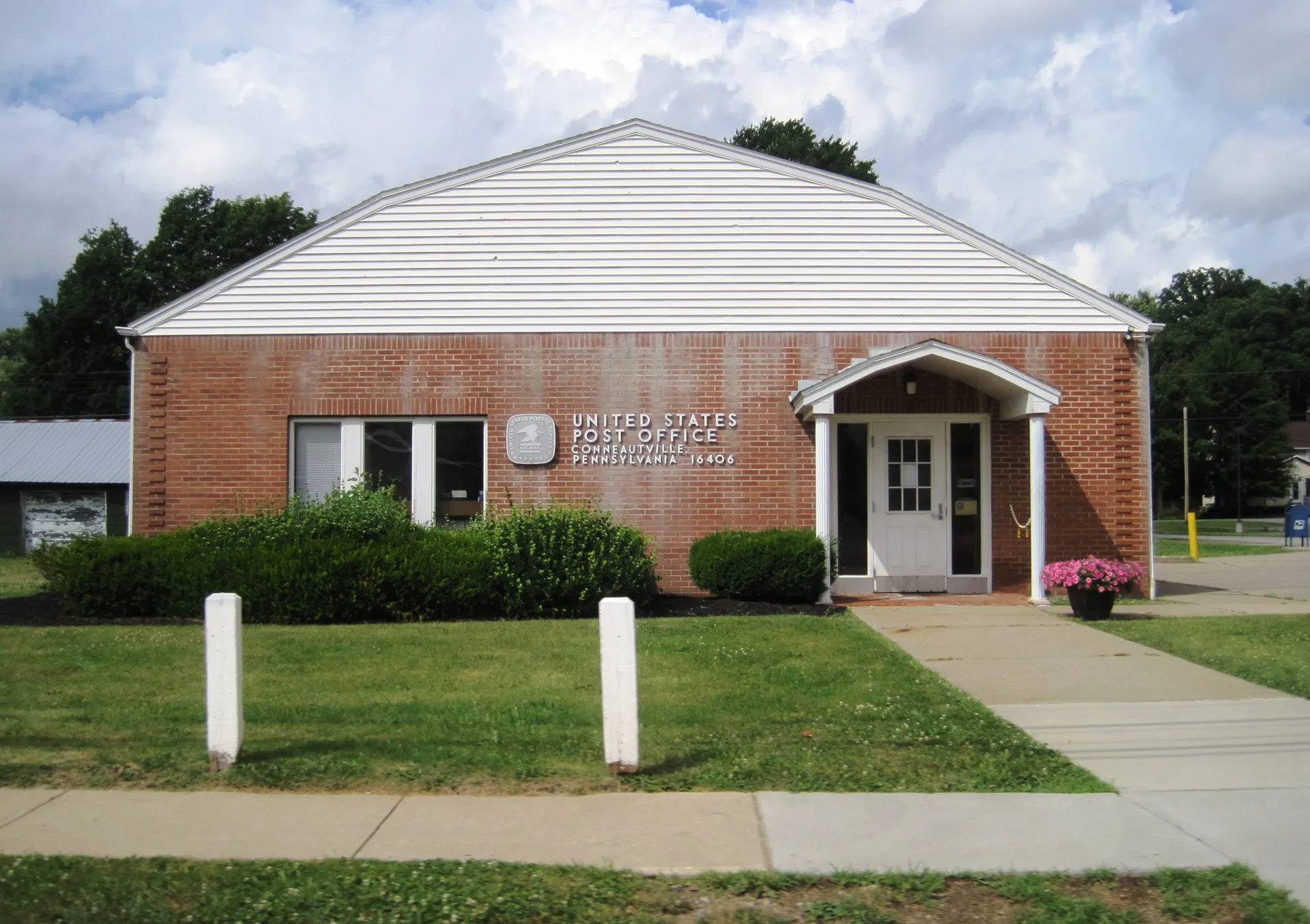Conneautville's post office is a red-brick building with a white pedimented entry, set behind a small lawn on Main Street.