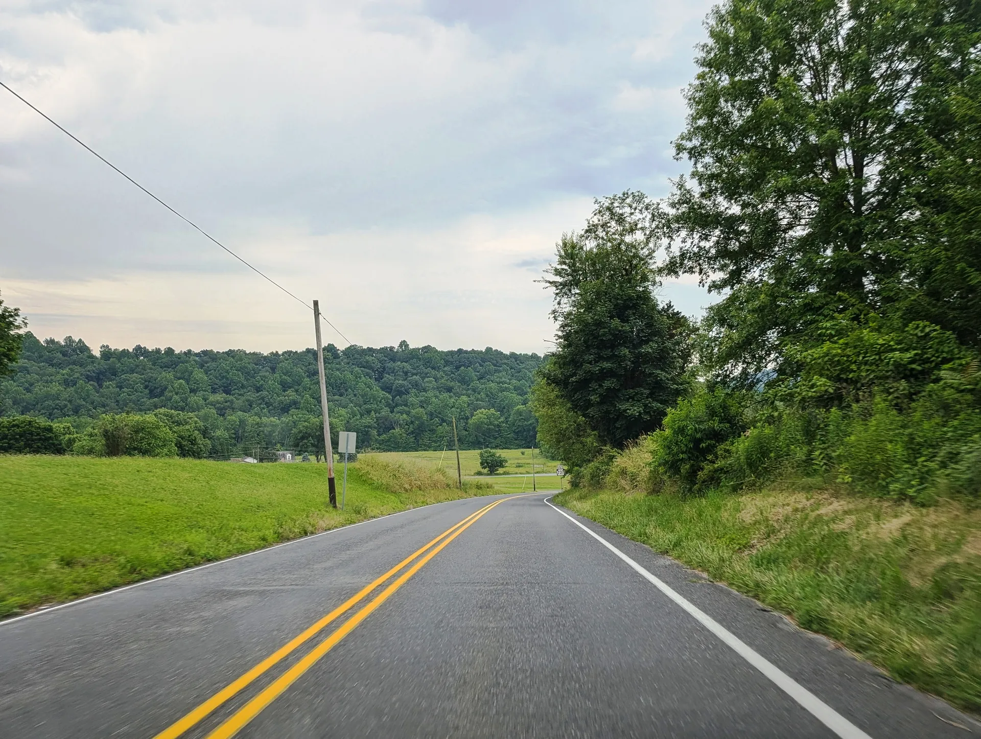Route 143 leads south past fields and a wooded ridge toward its junction with Route 737 in the Albany Township village of Kempton.