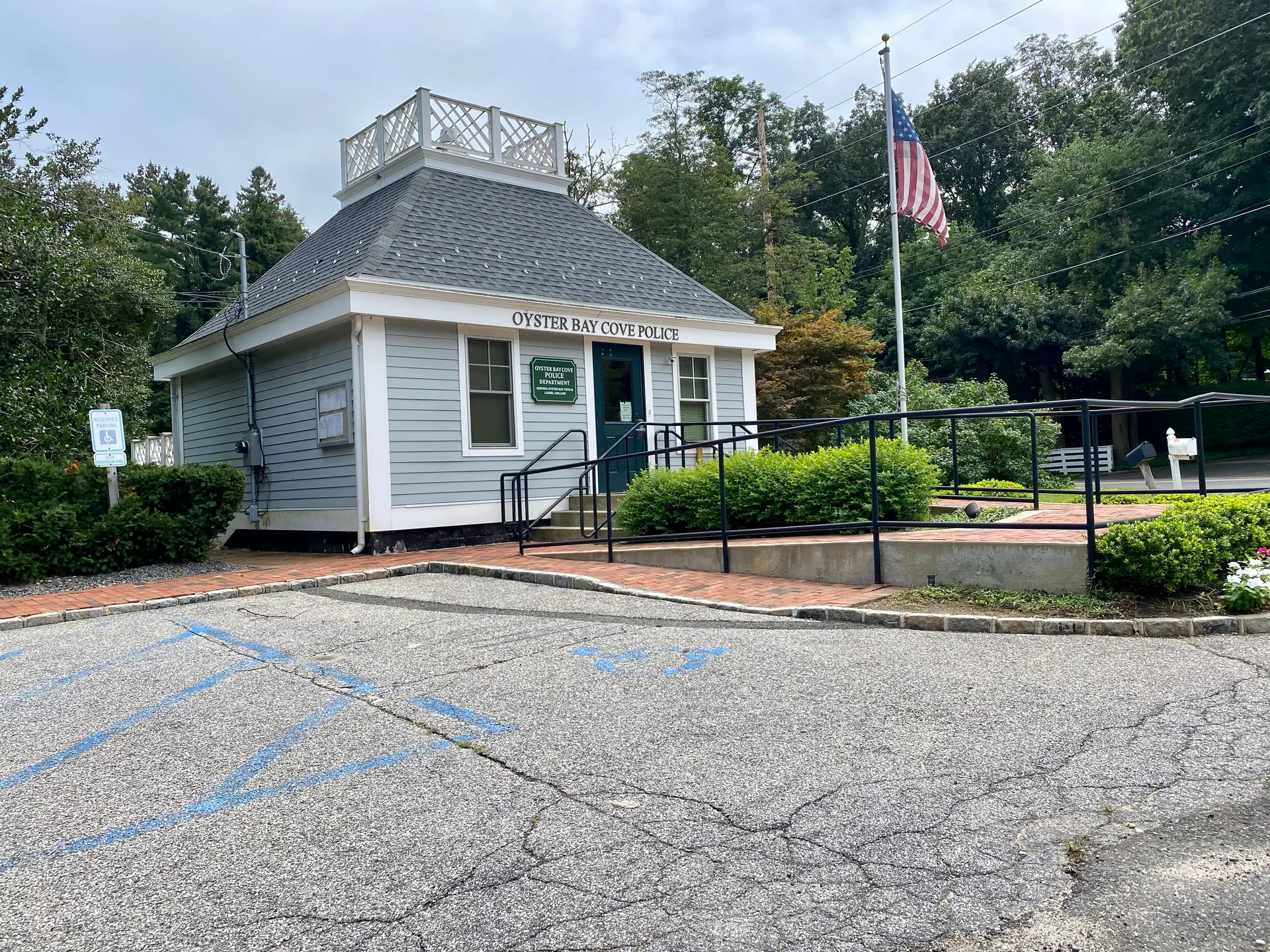 Oyster Bay Cove Police Headquarters cottage with a flag in Oyster Bay Cove, New York.