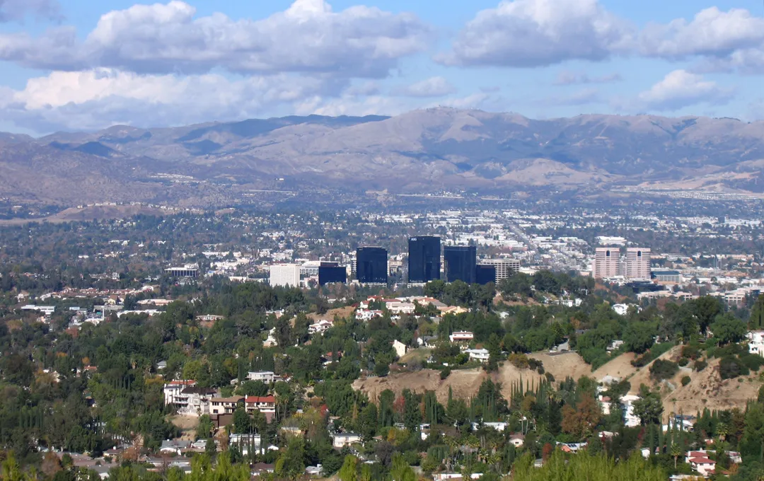 Archival hillside view across Woodland Hills and Warner Center toward the San Fernando Valley and distant mountains.