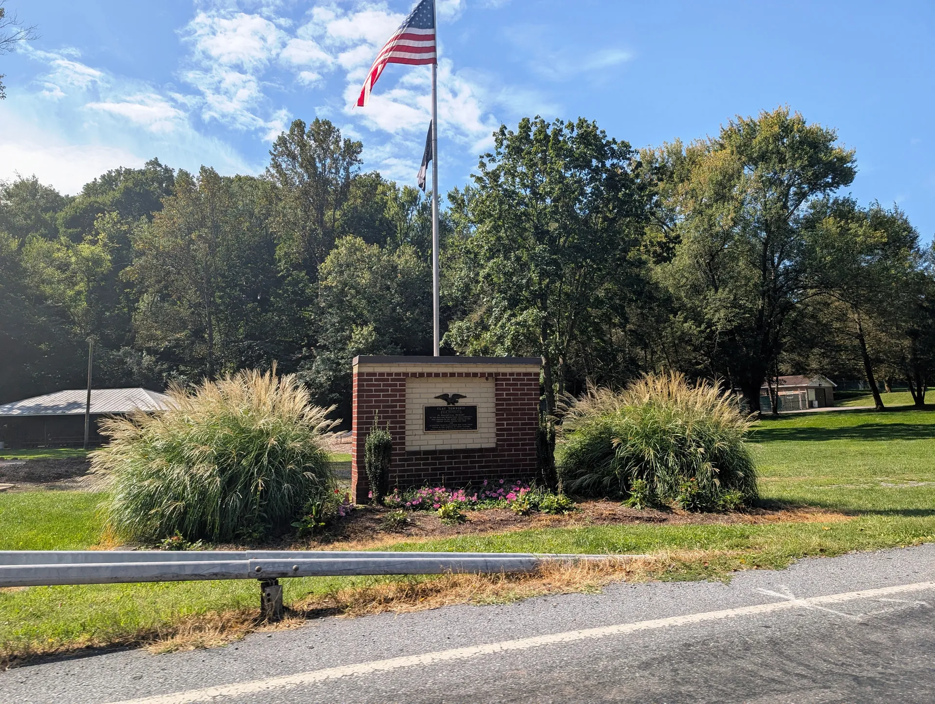 A veterans memorial with an American flag and landscaped plantings stands along Hopeland Road in the village of Hopeland.