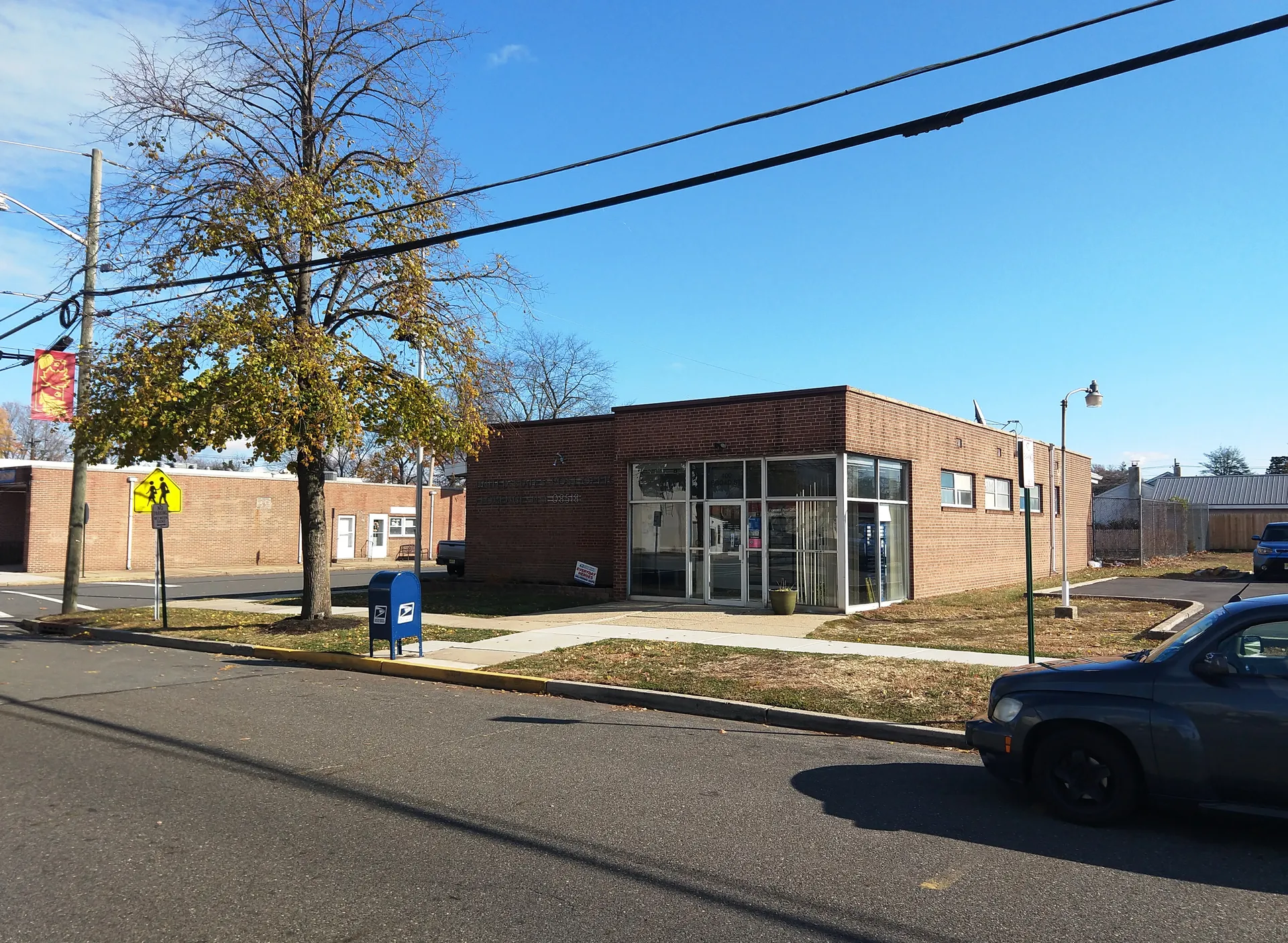 The Florence post office is a single-story brick building with a glass entry, set back from the street behind a small lawn.