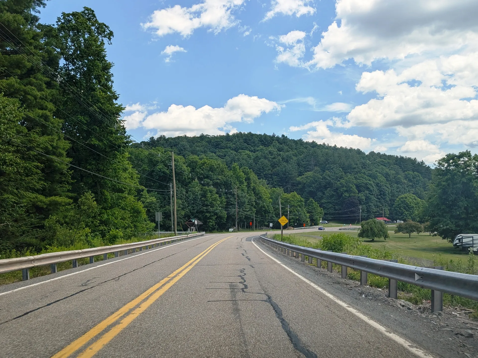 Hunlock Creek Turnpike curves east through Hunlock Township between wooded hills and a guardrail.