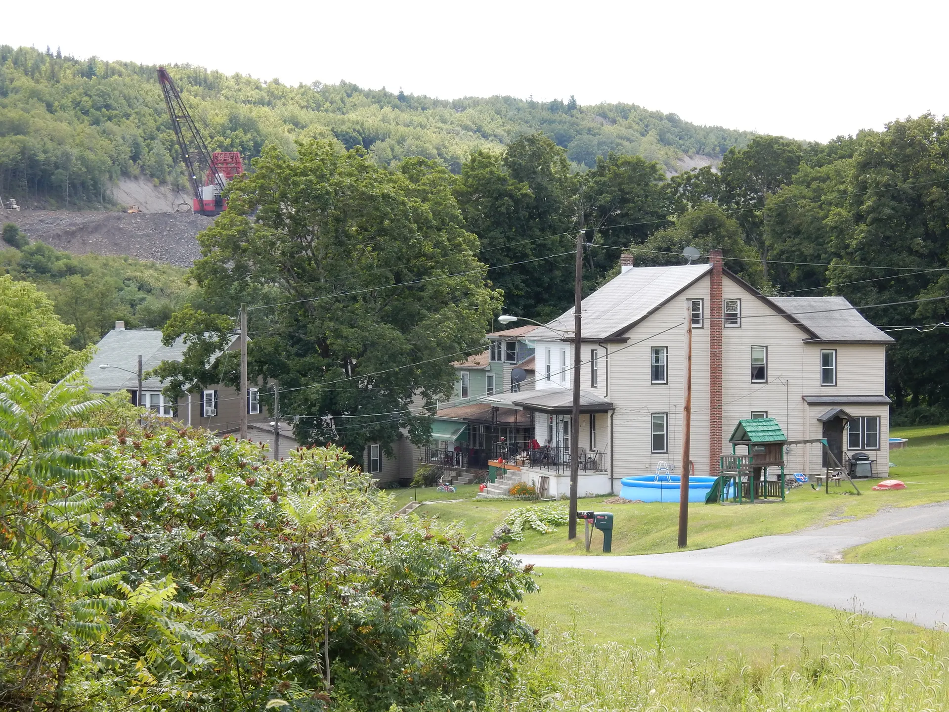 From Valley Road, Thomaston Road leads south past a two-story house in Heckscherville, with mining equipment visible on the hills.