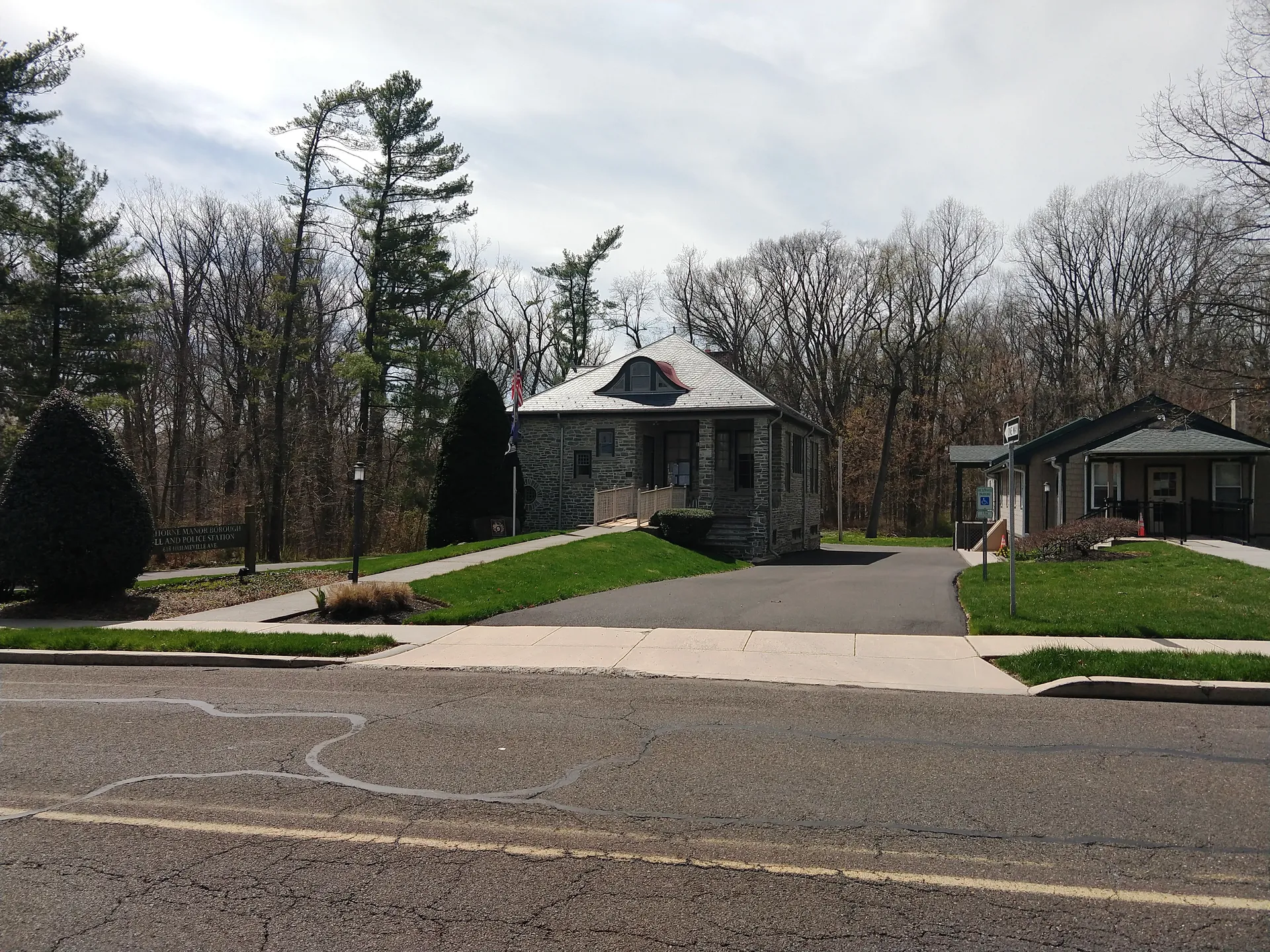 Langhorne Manor's borough hall is a small stone-and-shingle building framed by trees on Hulmeville Avenue.