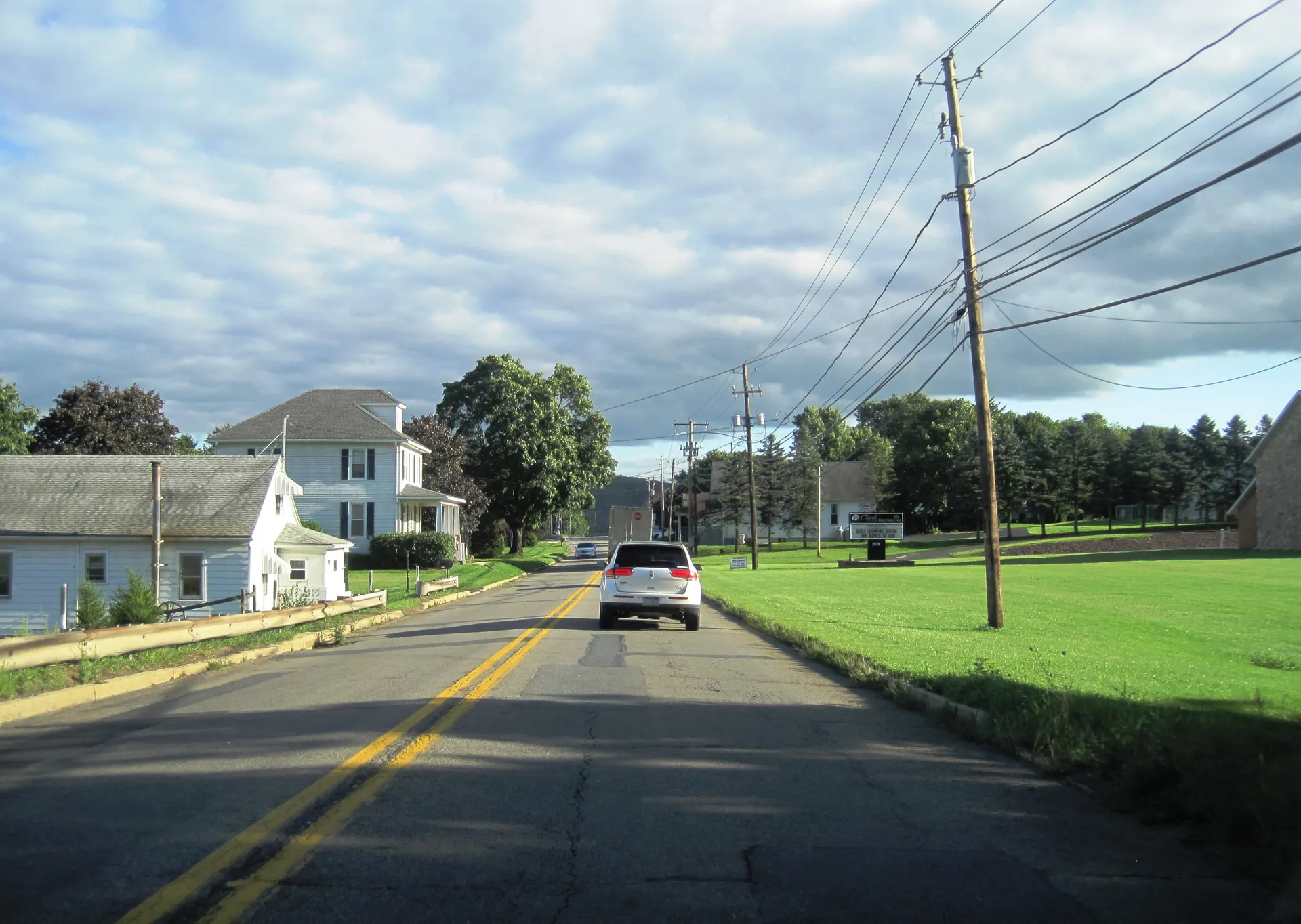 Fairgrounds Road (Route 901) heads south through the village of Lavelle in Butler Township past houses and fields.