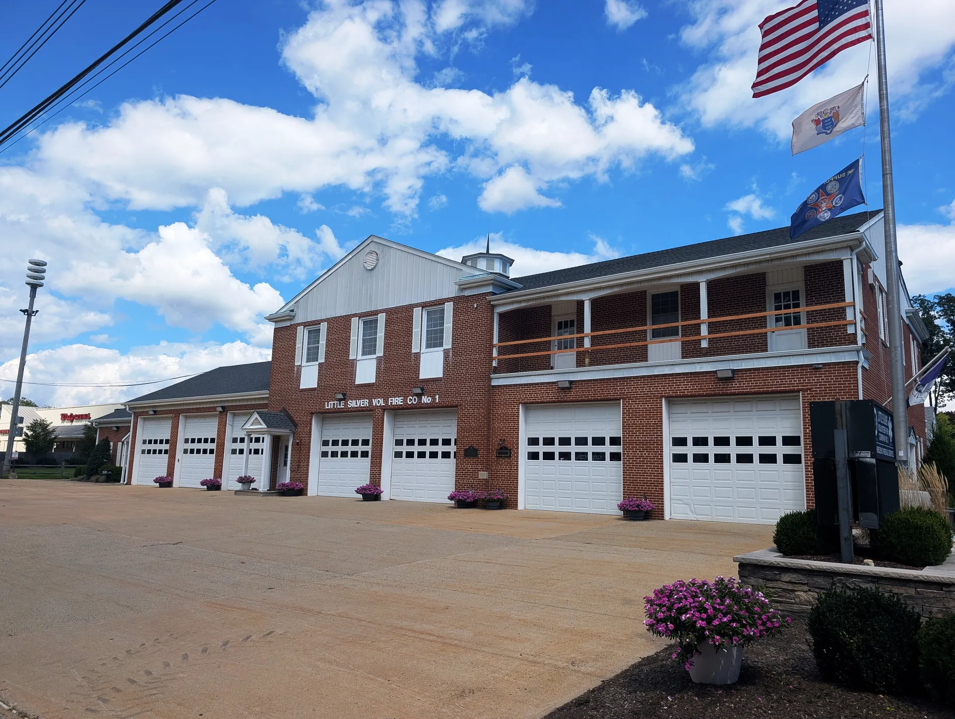 Little Silver Volunteer Fire Company occupies a red brick firehouse with white bay doors and a balcony above.