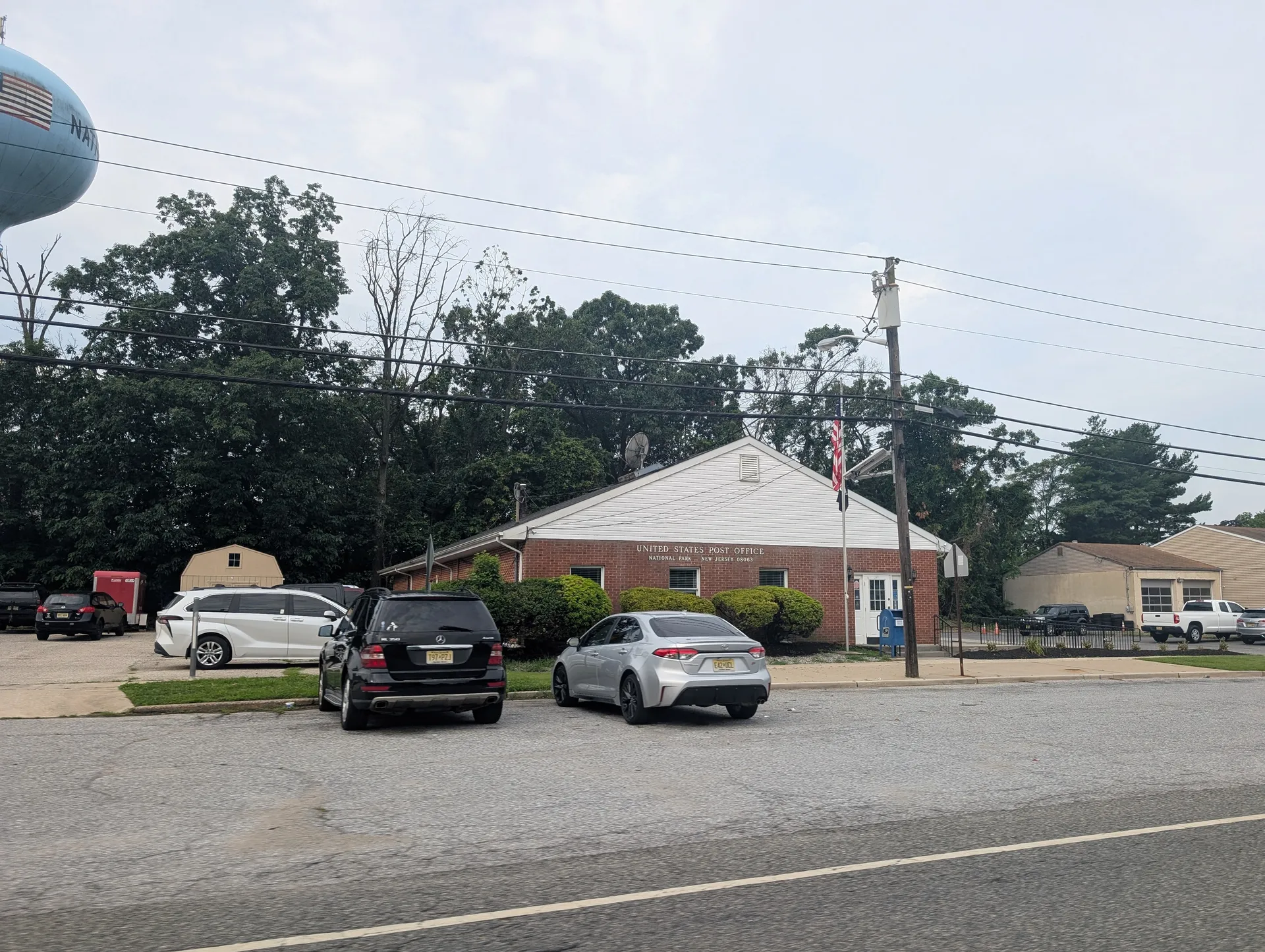 National Park's post office is a small red-roofed brick building beyond a parking area with a few cars.