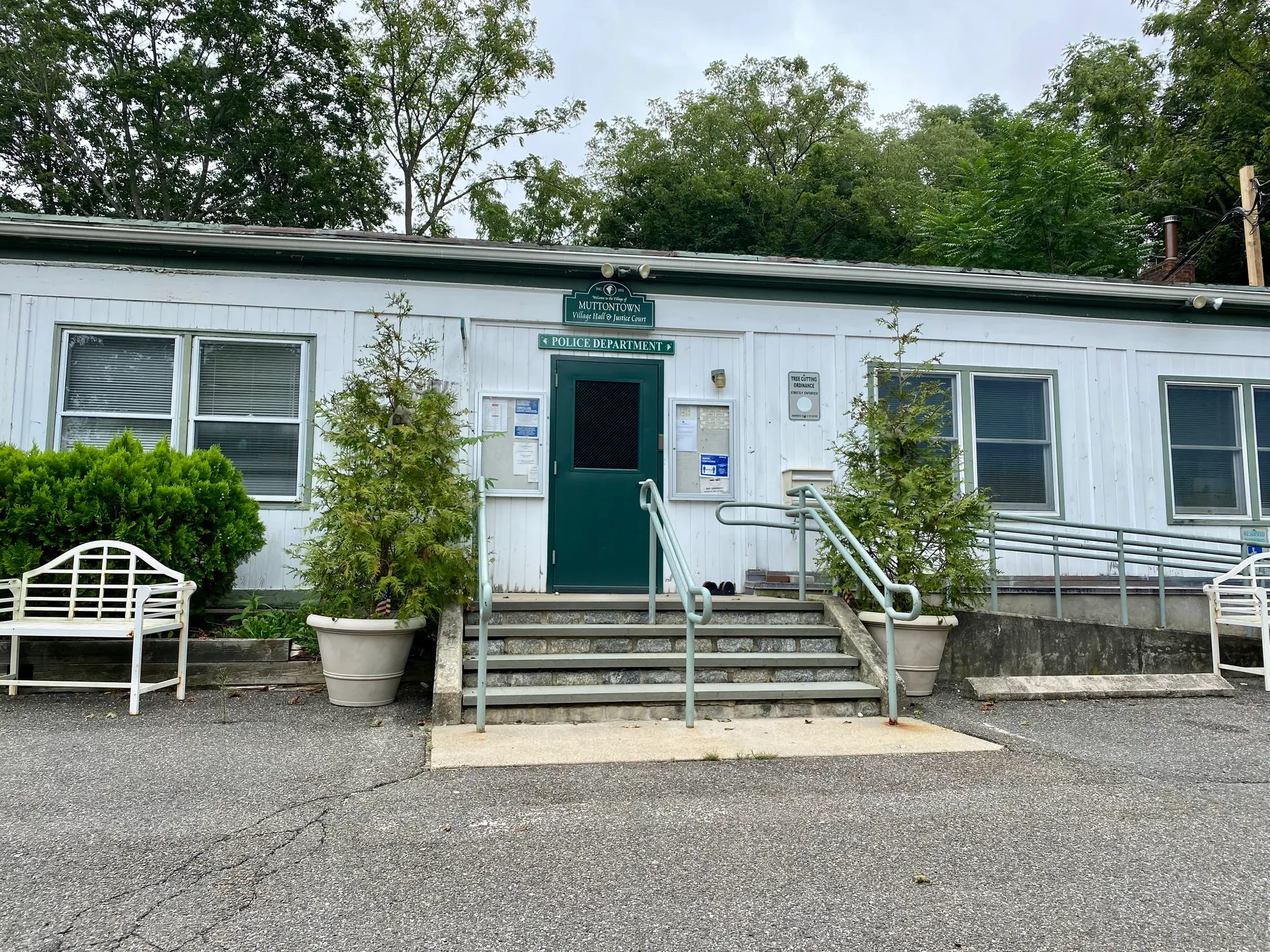 Muttontown Village Hall building with potted plants in Muttontown, New York.
