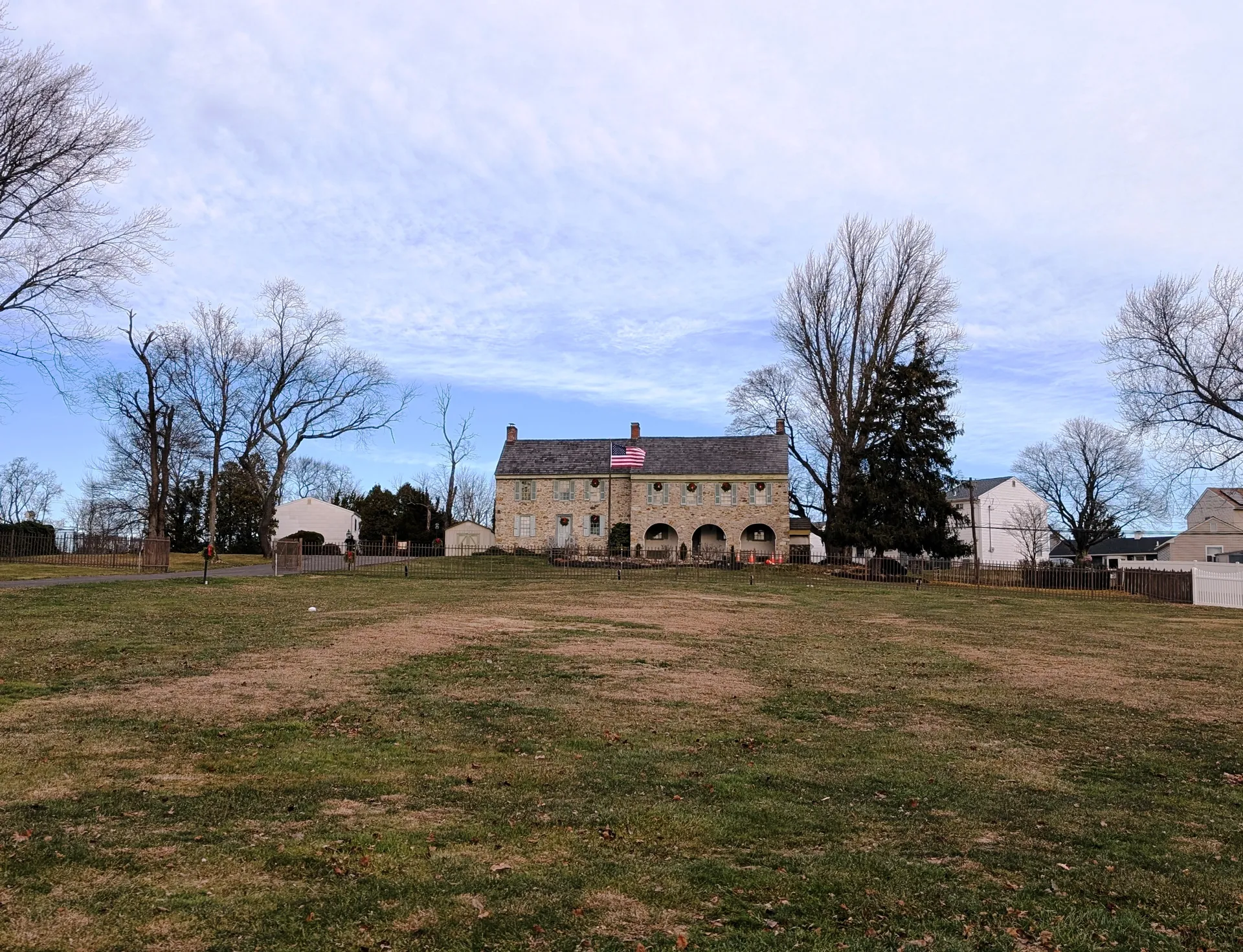 The Sotcher Farmhouse, known as the Three Arches house, stands beyond an open lawn on Trenton Road in Fairless Hills.