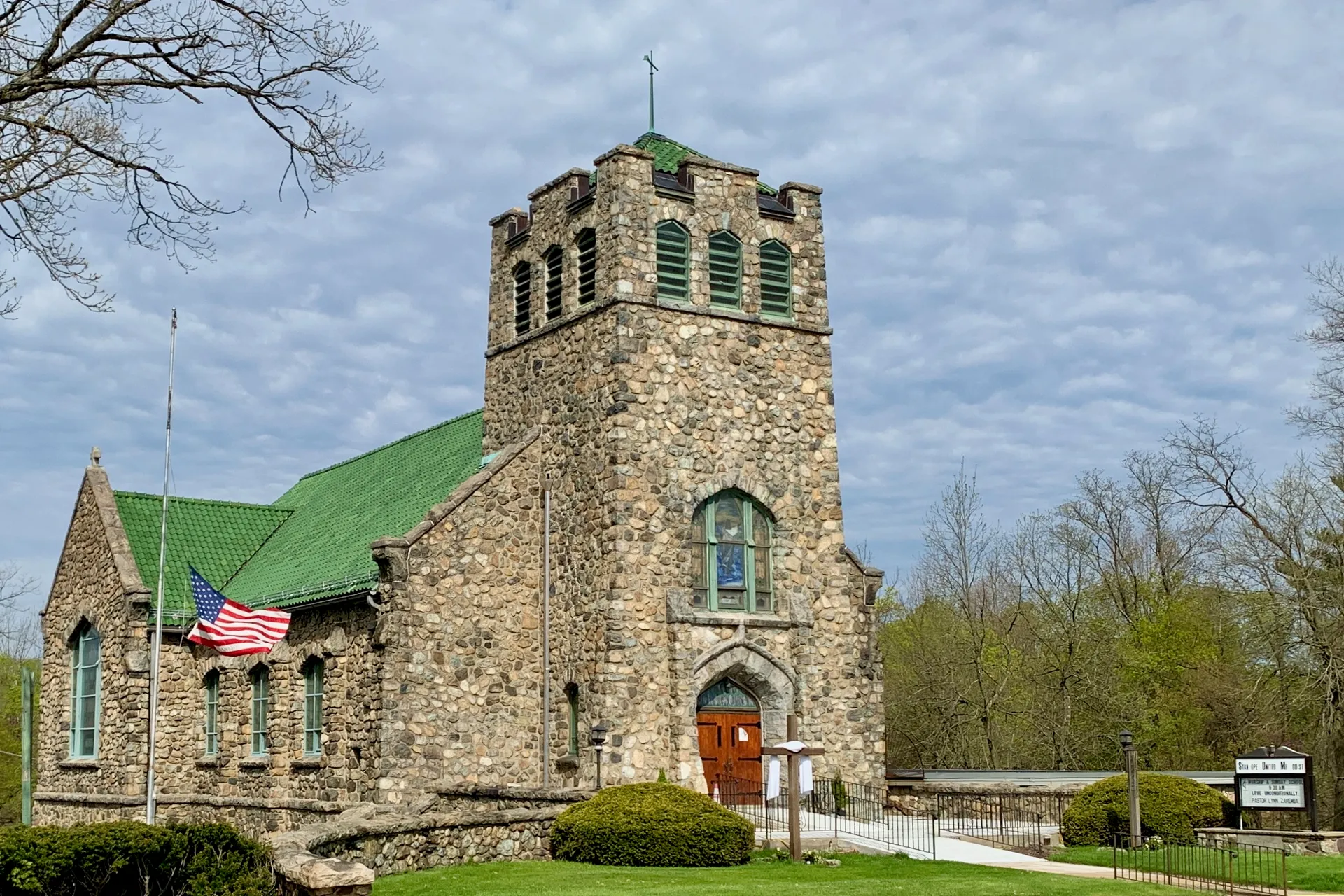 Stanhope United Methodist Church in Netcong is a rough stone church with a battlemented tower and a red door.