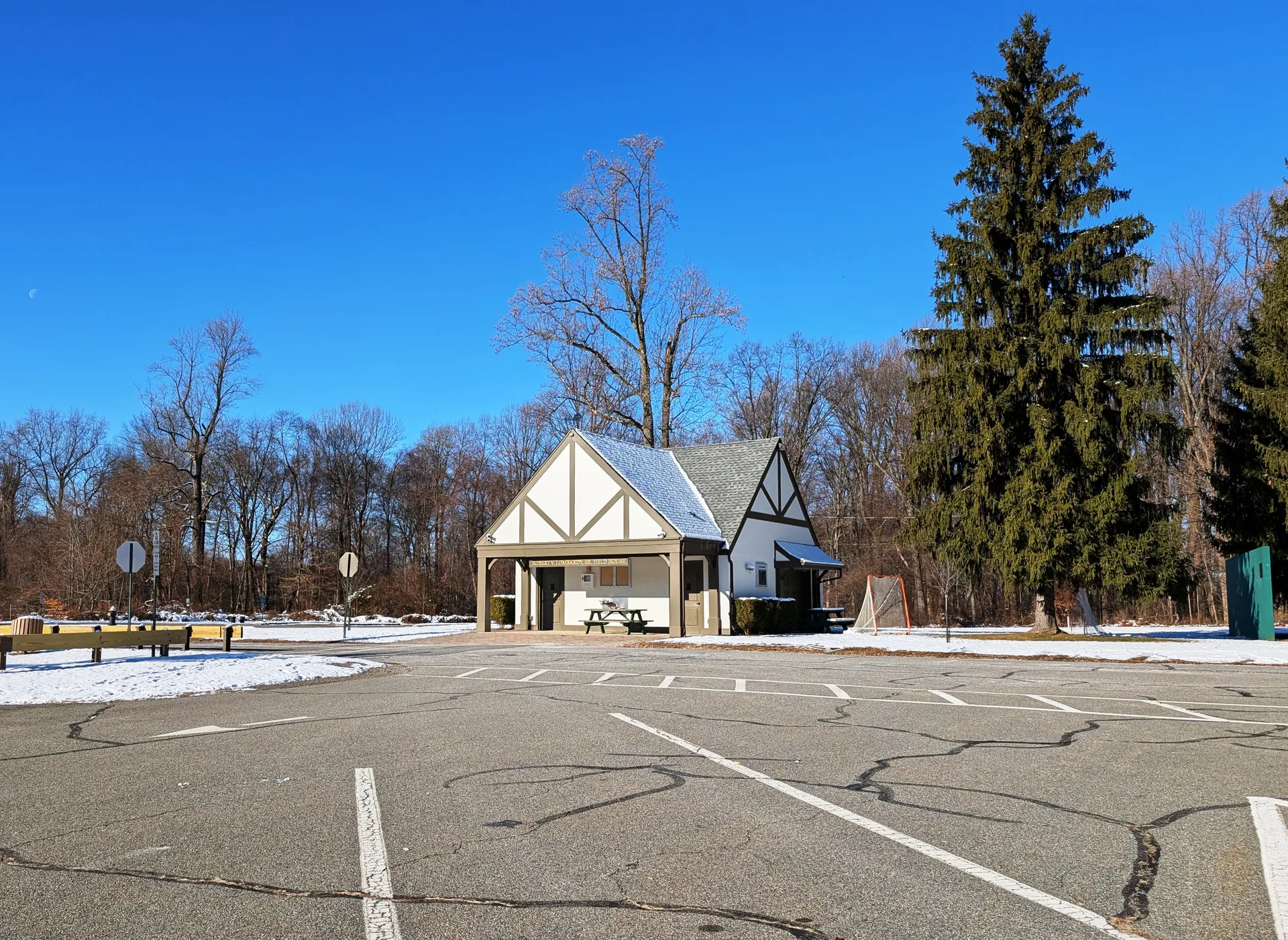 The Robert Lombardy Sr. Field House in Essex Fells is a small Tudor-style building at the edge of a lot ringed by trees.