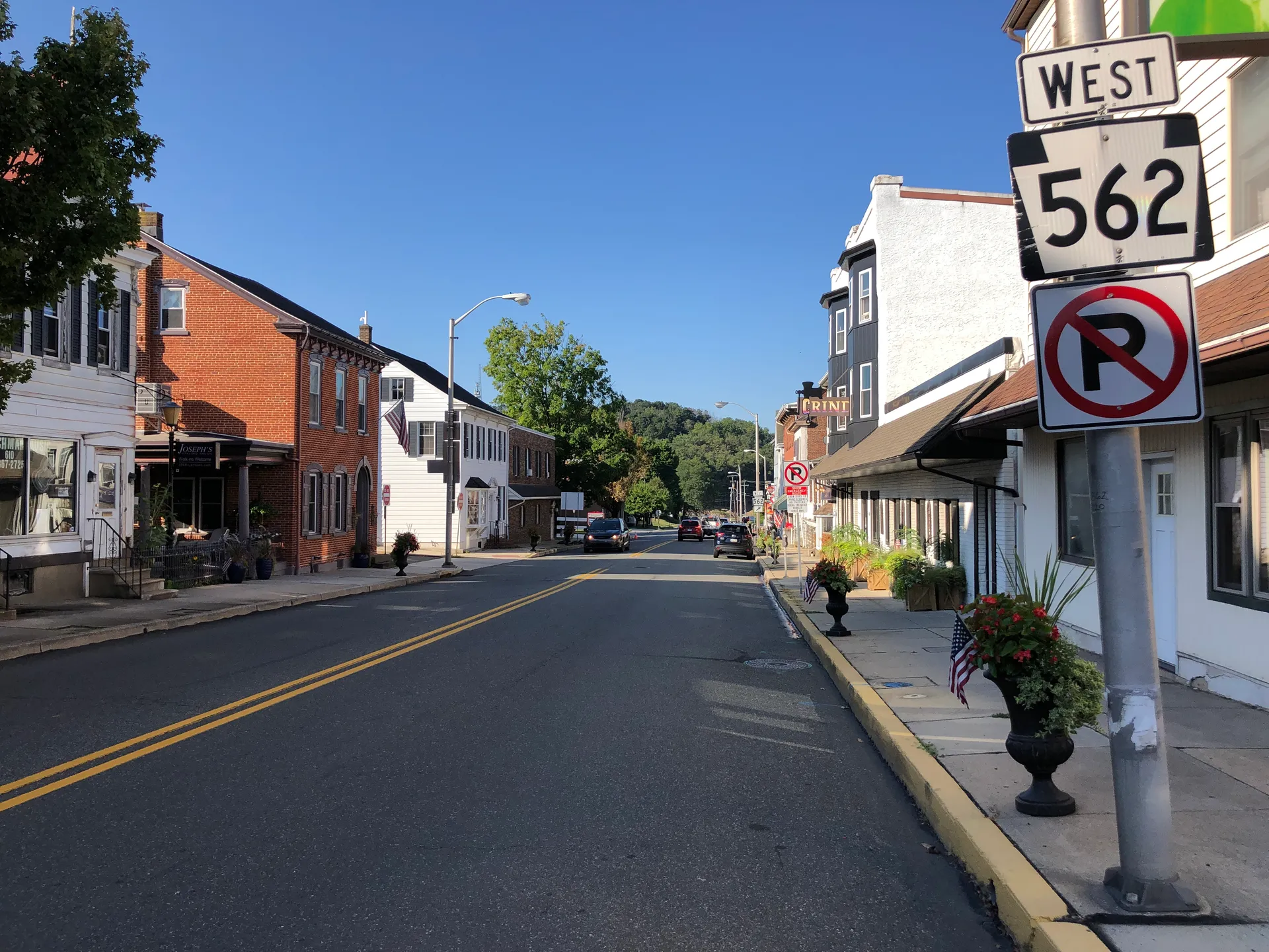 Reading Avenue (Route 562) in Boyertown runs west past brick storefronts, porches and parked cars under a deep blue sky.
