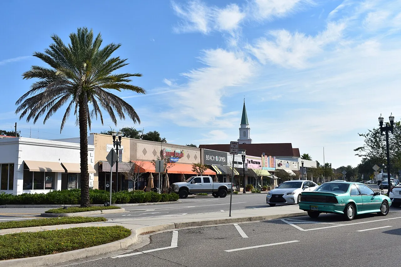 Storefronts, a palm tree and street traffic near Balis Park in San Marco, Jacksonville, photographed in October 2020.