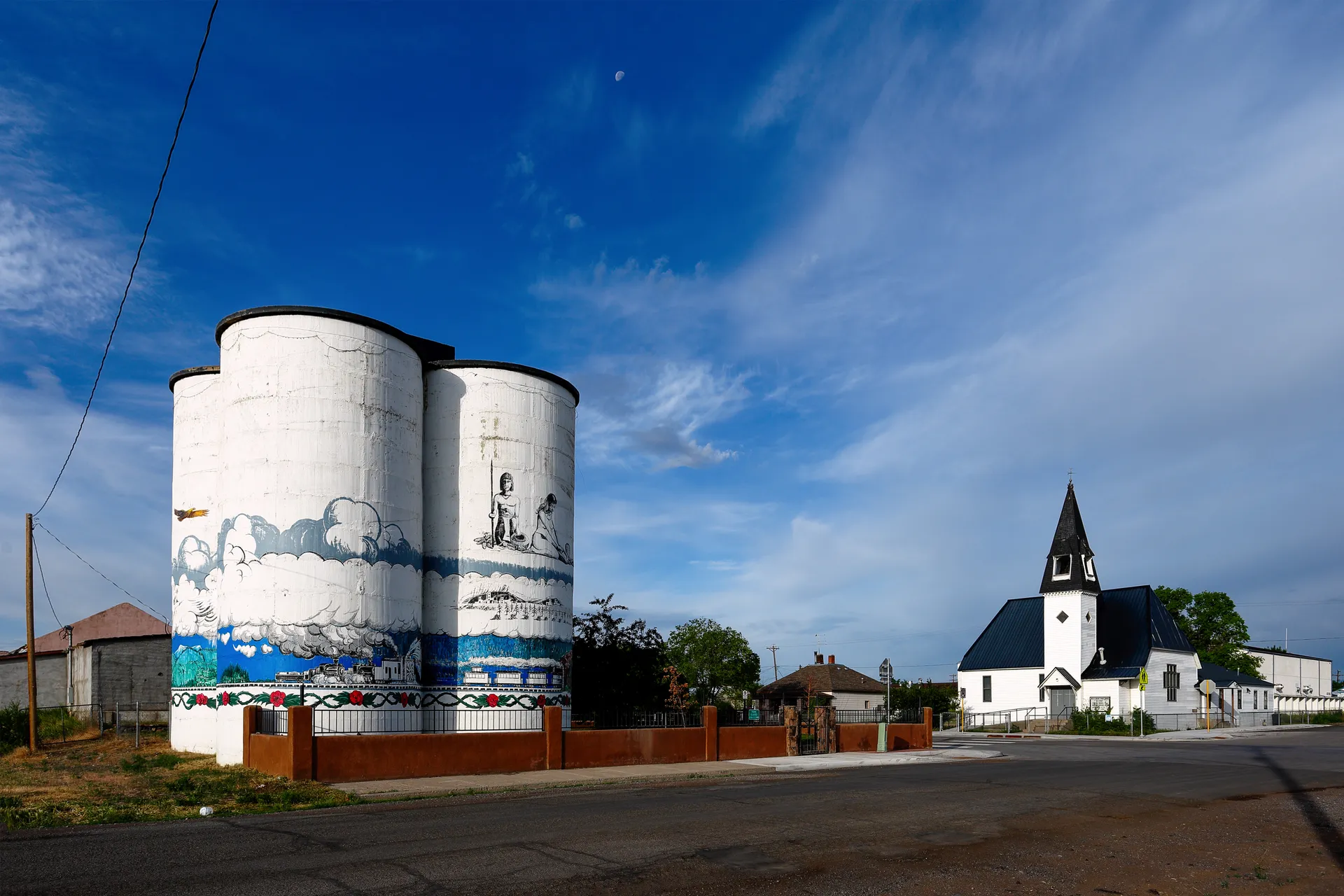 Painted grain silos and Presbyterian church in Antonito, Colorado.