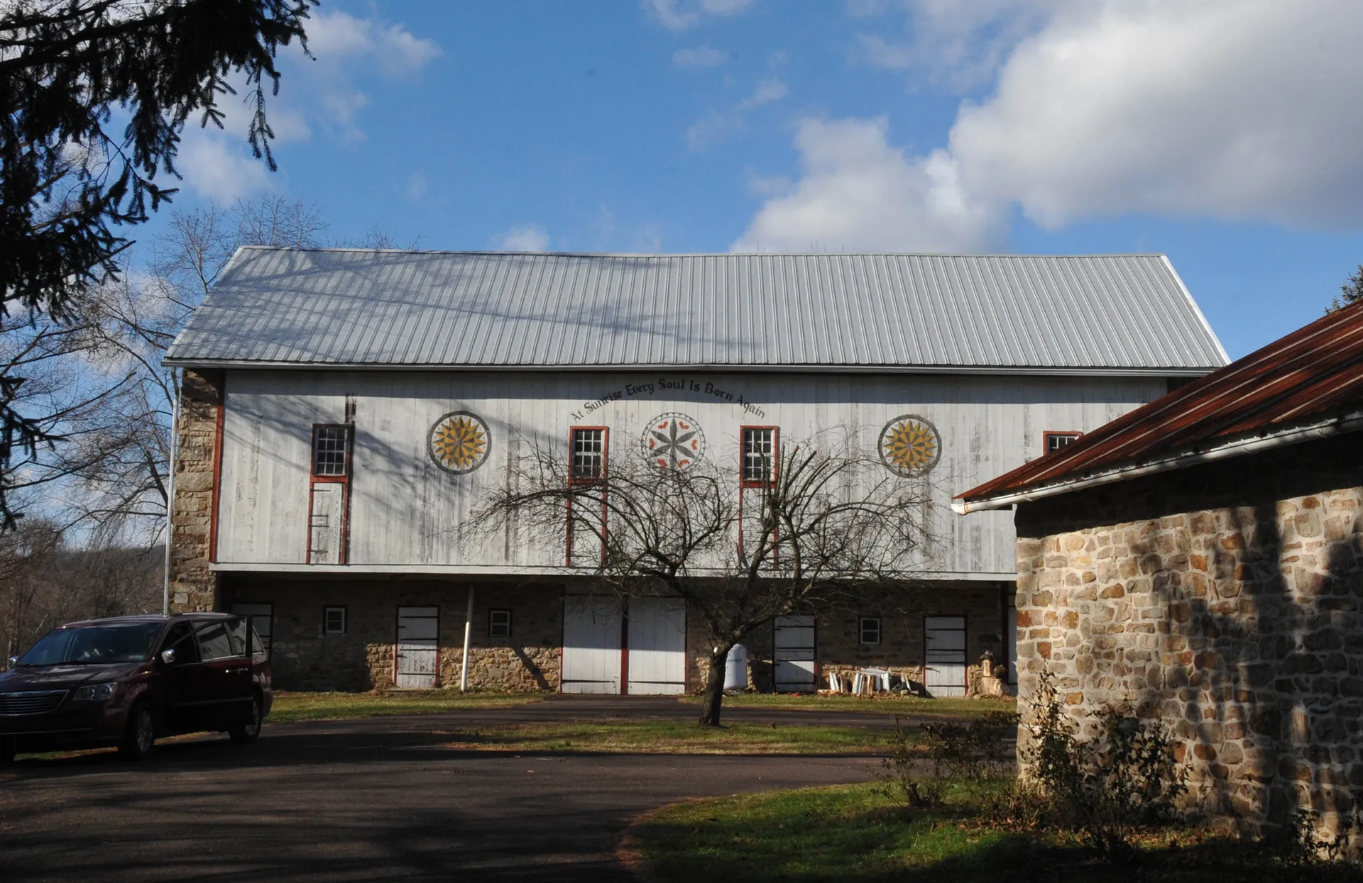 The Hunters Mill complex in Hereford Township includes a mid-19th-century bank barn whose gable bears hex signs and a painted inscription.