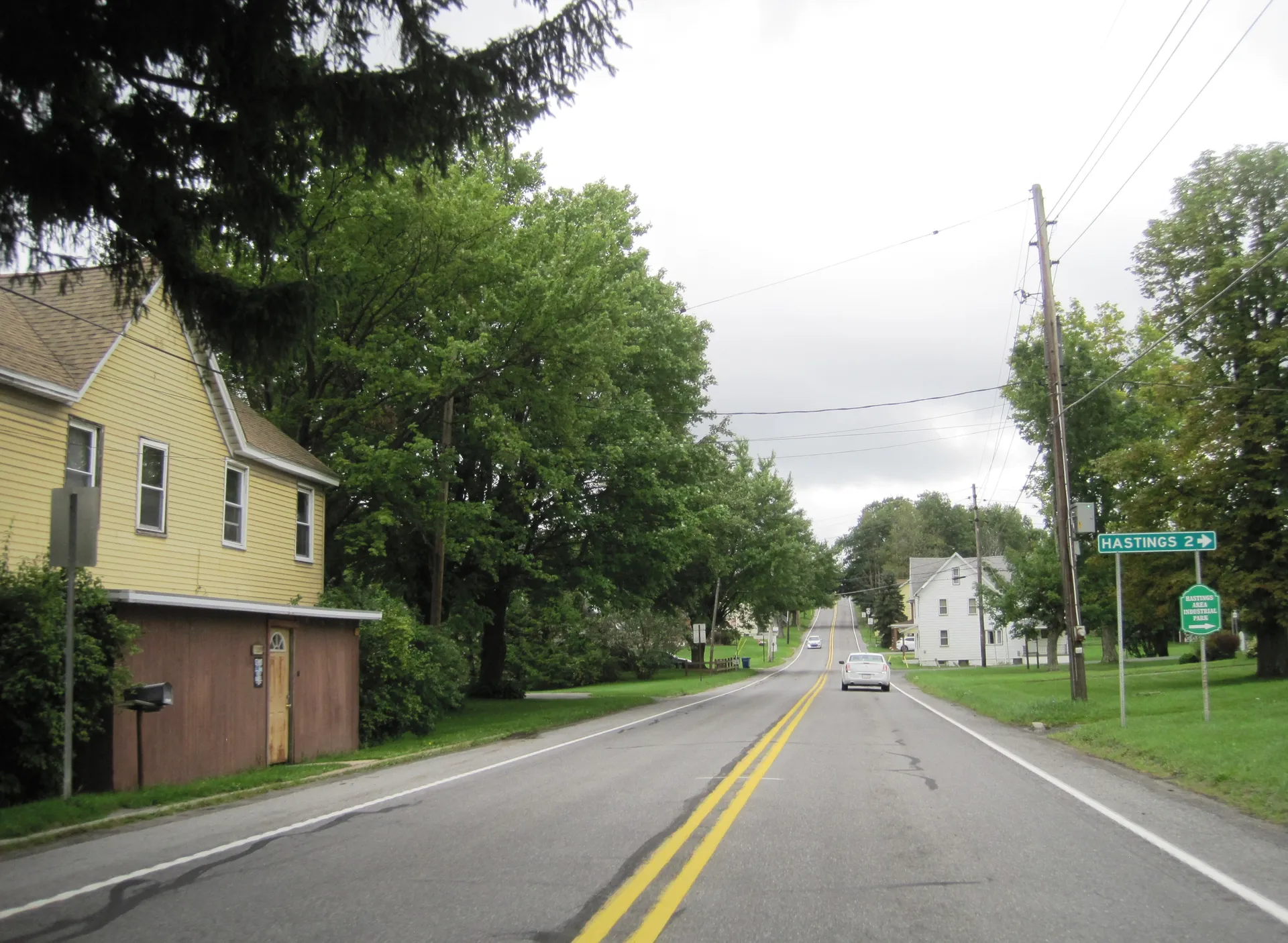 Main Street (Route 36) runs south through St. Boniface in Elder Township, shaded by tall trees with a few homes along the way.