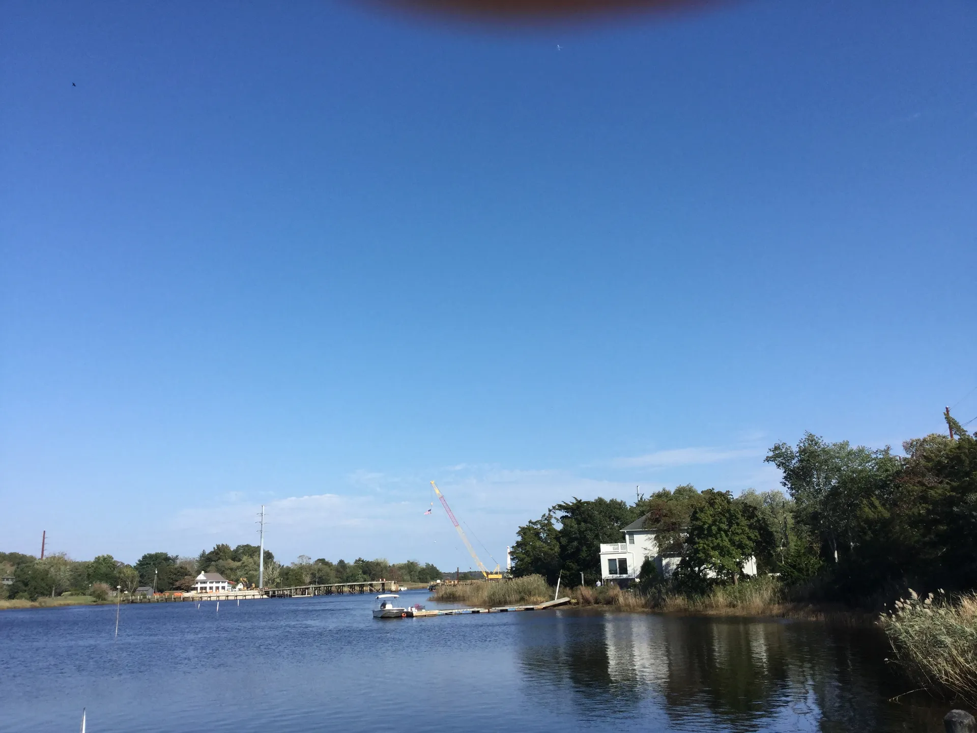 Nacote Creek in Port Republic winds past a marina and green trees under a deep blue sky.