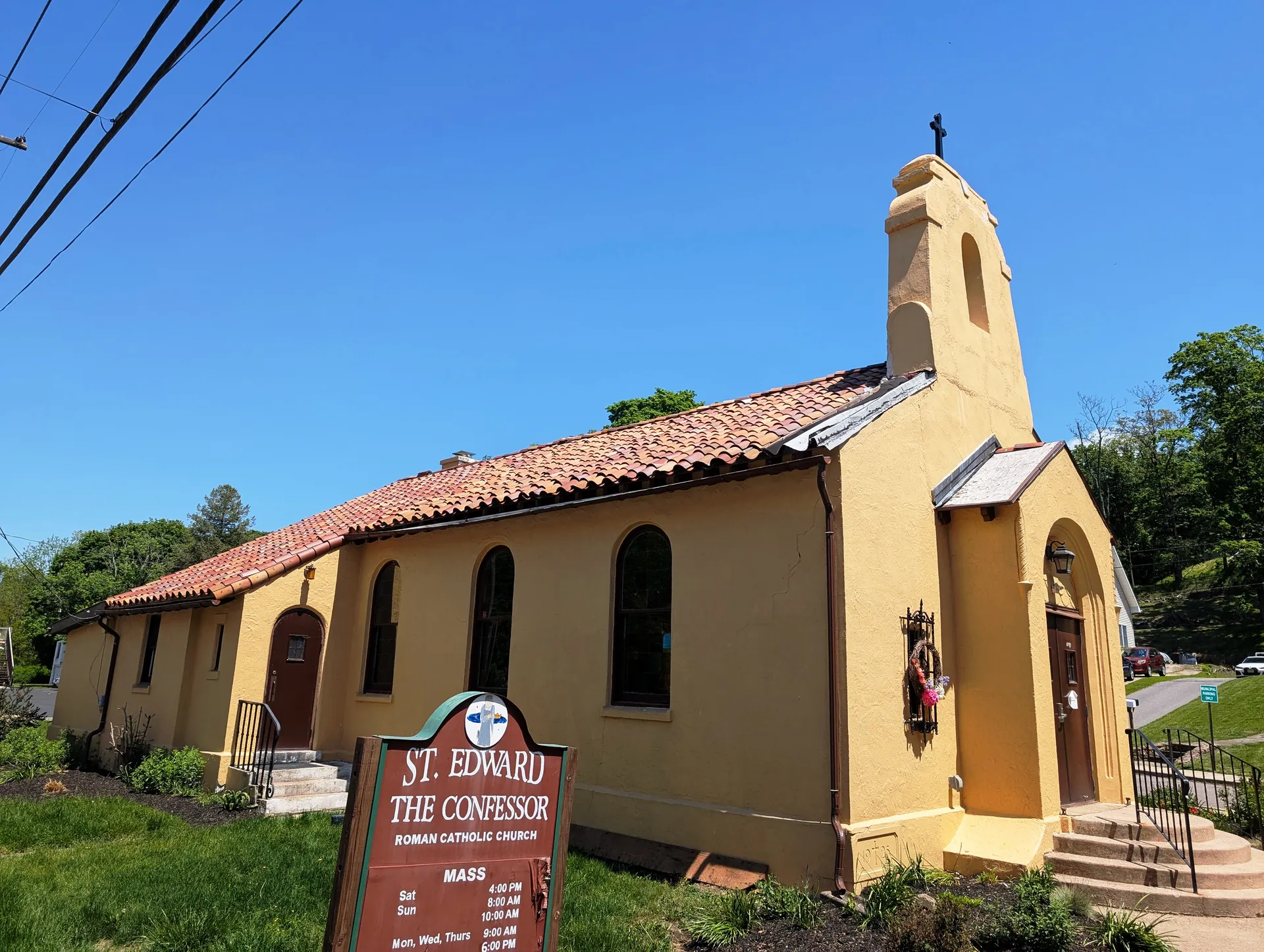 St. Edward the Confessor Roman Catholic Church in Milford is a golden stucco church with a red tile roof and a small bell tower.