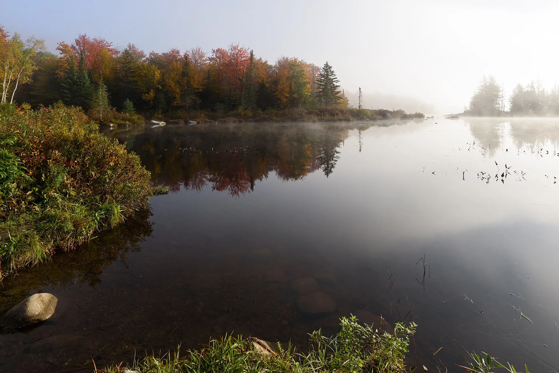 Marshfield Pond reflecting fall foliage in Marshfield, Vermont.