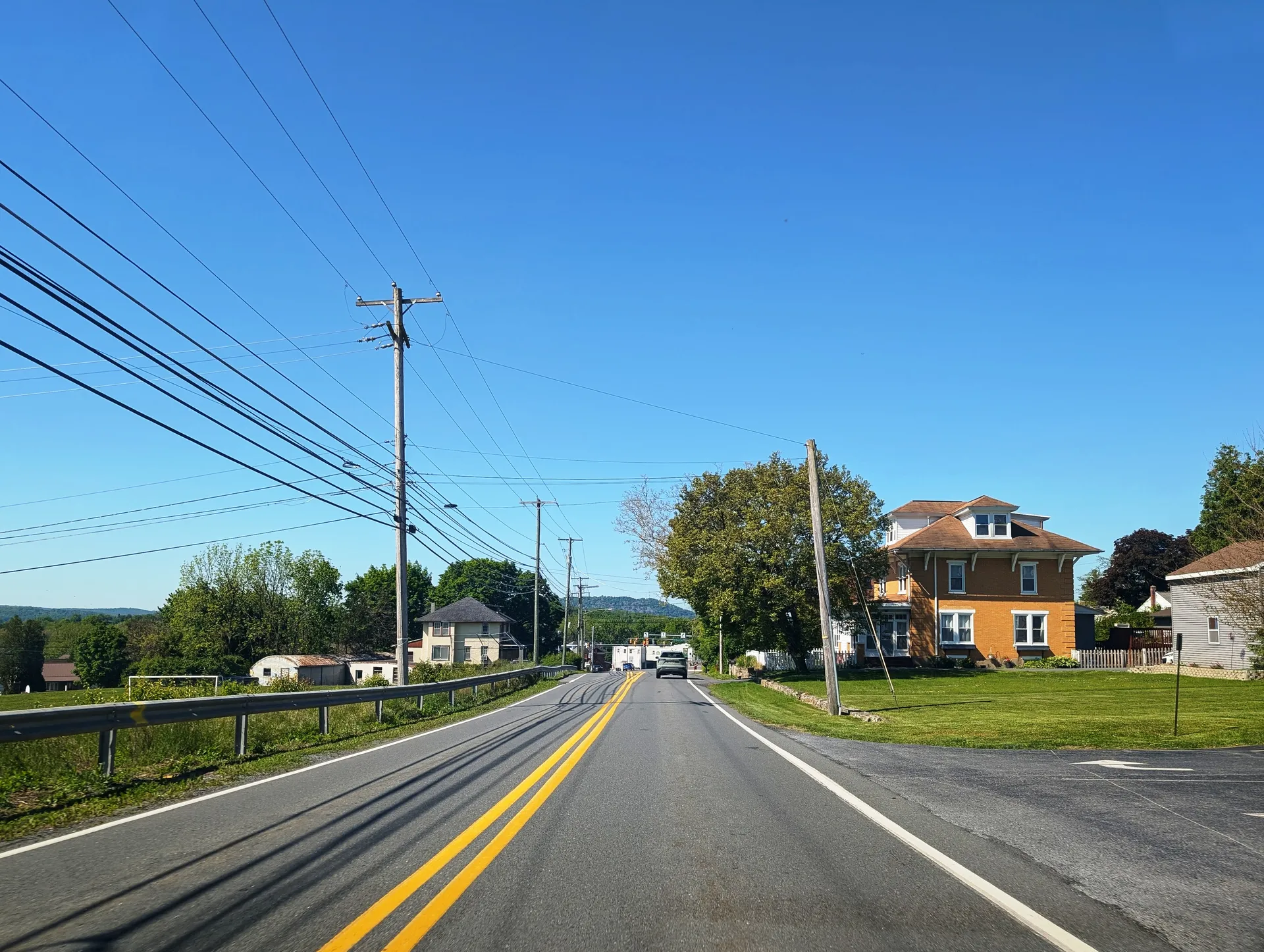 Oley Turnpike Road passes a brick farmhouse in the village of Jacksonwald in Exeter Township, Berks County.