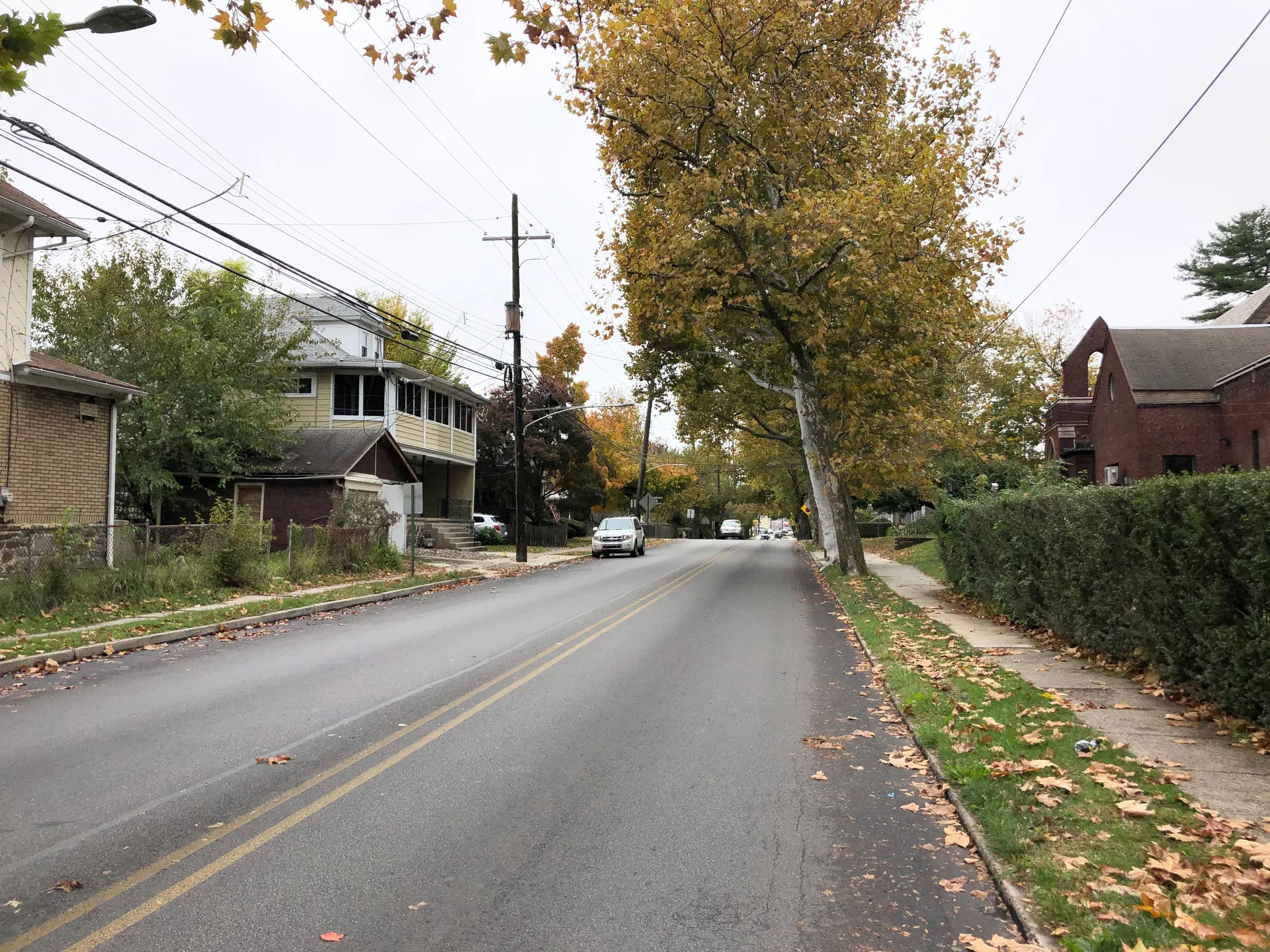 Pembroke Avenue runs west at Penn Boulevard in East Lansdowne, lined with porches and trees showing fall color.