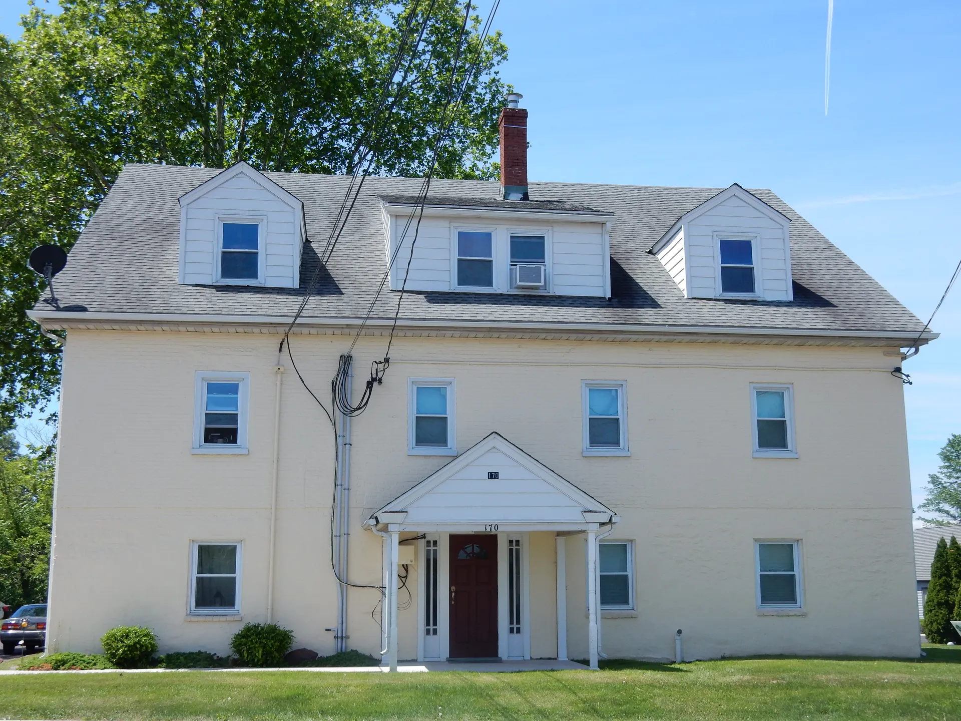 A cream-colored two-and-a-half-story house with dormers and a pedimented doorway stands at 170 North Main Street in Dublin.