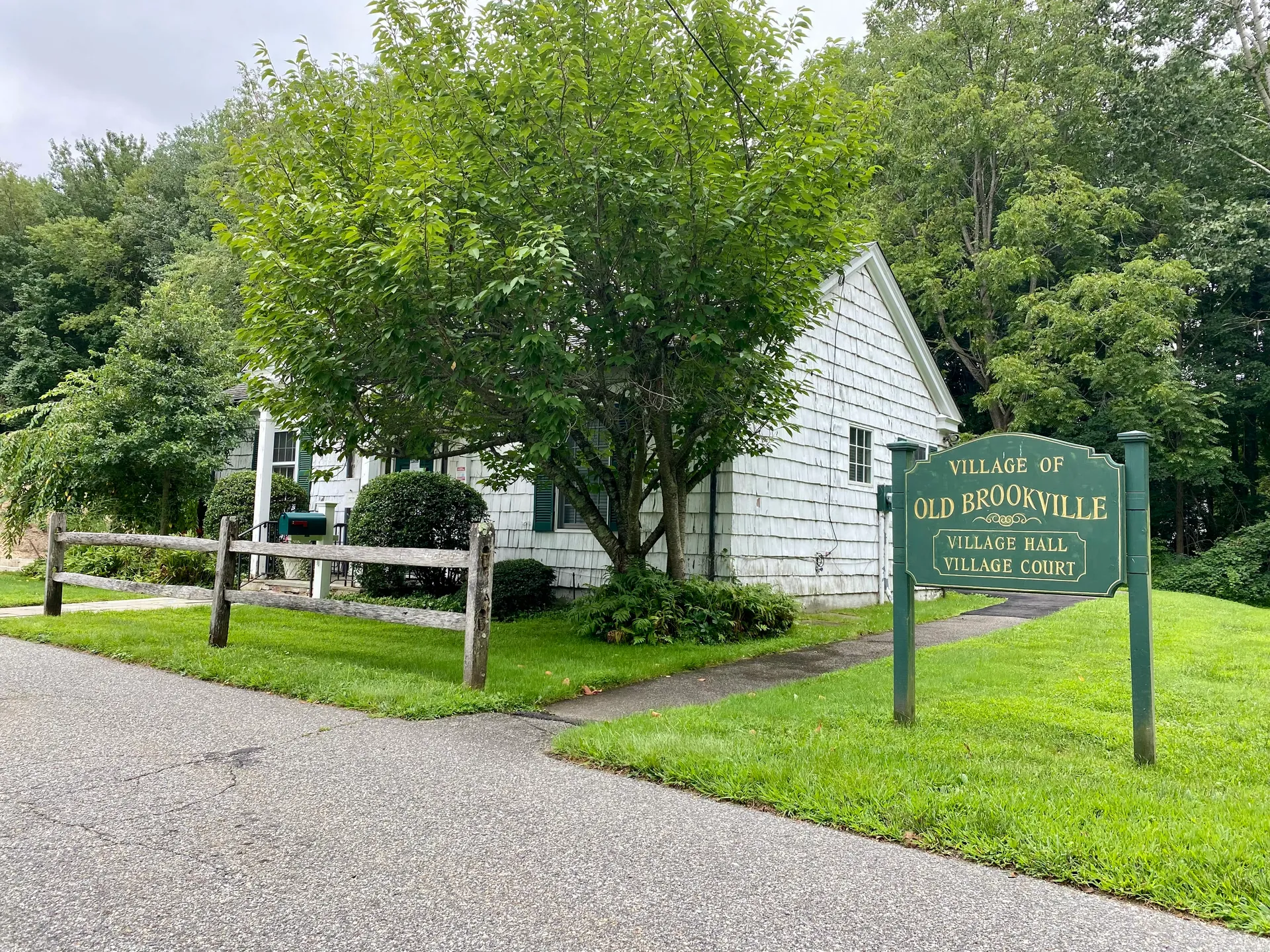 Old Brookville Village Hall with a white building and sign in Old Brookville, New York.