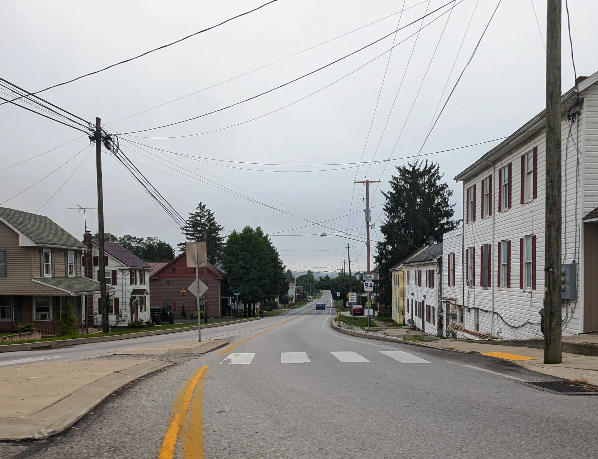 Carlisle Pike reaches a roundabout in Hampton, an Adams County village in Reading Township, with old houses lining the shoulders.