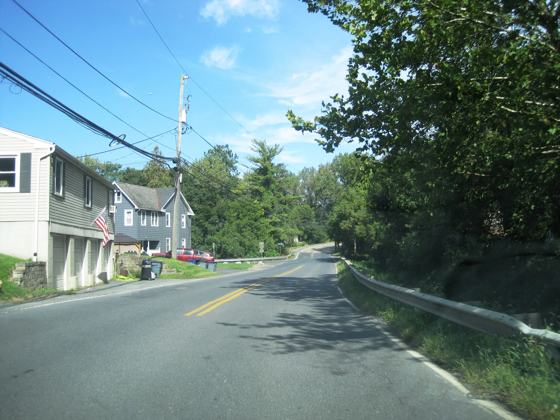 Berger Road becomes Main Street in Glendon, heading north at Willow Street past homes and trees.