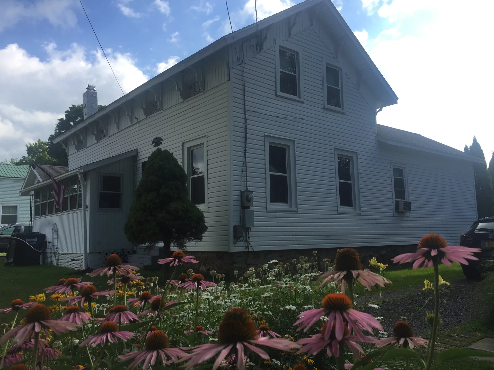 White clapboard houses with flower gardens in Meridian, New York.