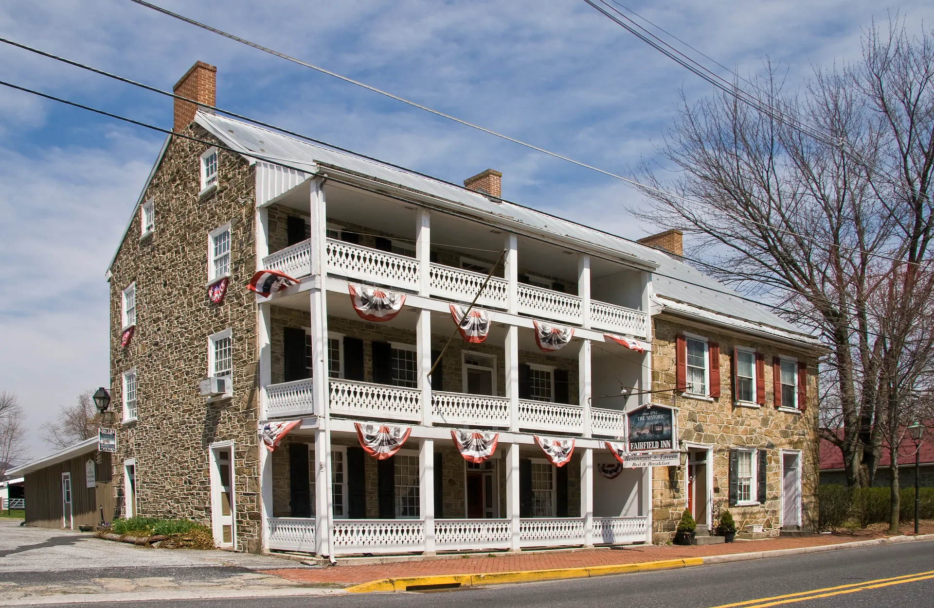 The historic Fairfield Inn is a stone building with tiered white porches decorated with patriotic bunting.