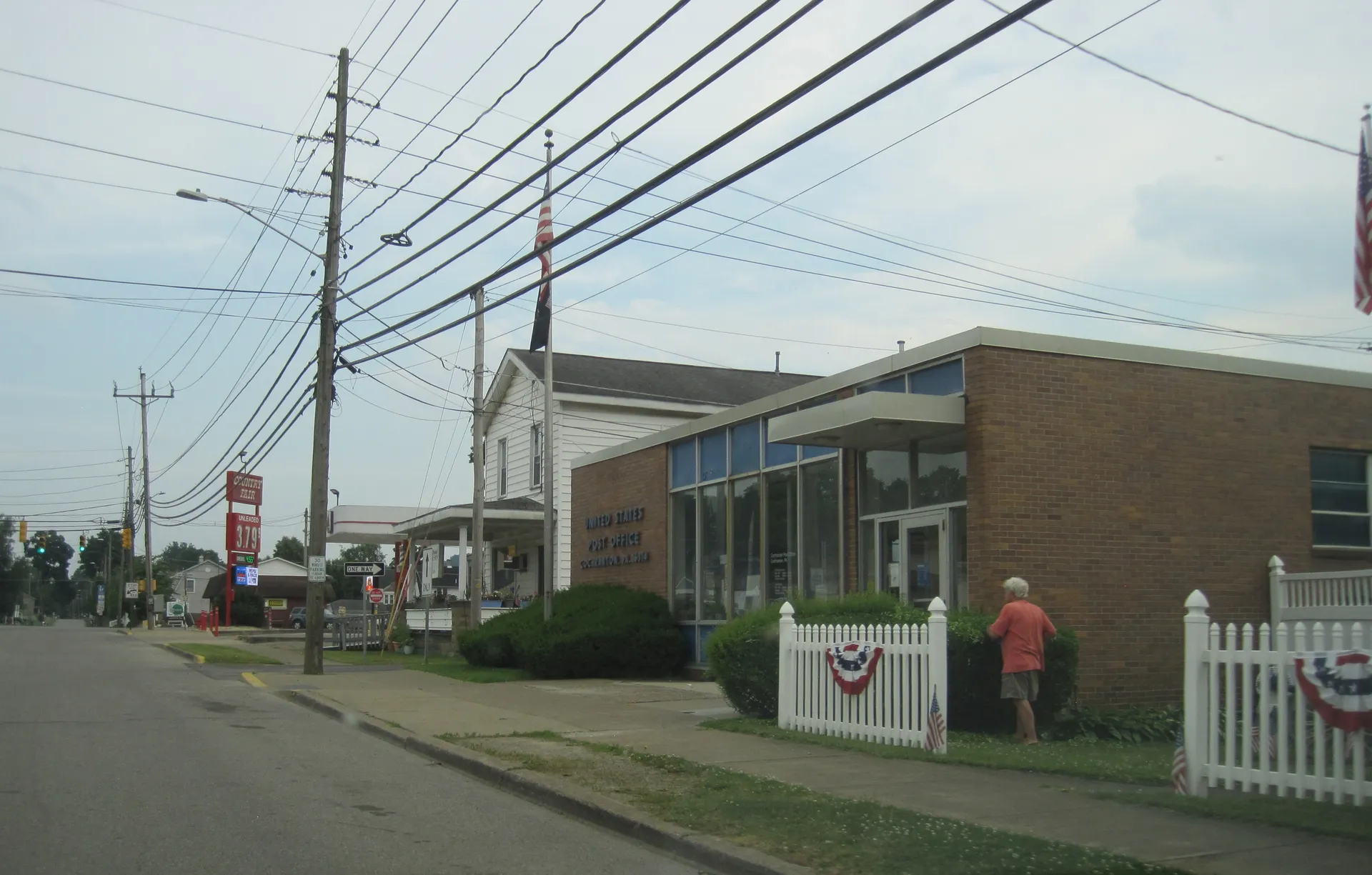 The Cochranton post office is a brick building with a broad glass front and bunting-trimmed fence along North Franklin Street.