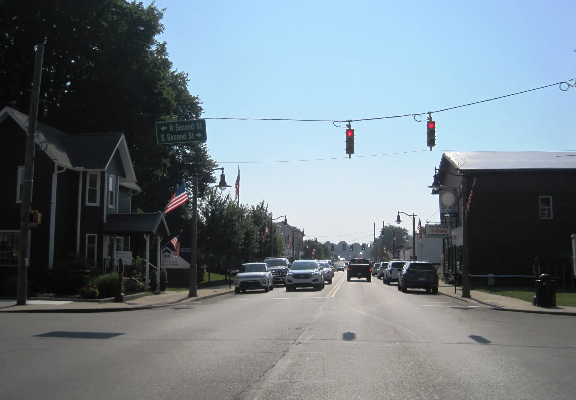 Water Street carries U.S. Routes 6 and 322 through Conneaut Lake at Second Street, with flags, shops and traffic signals.