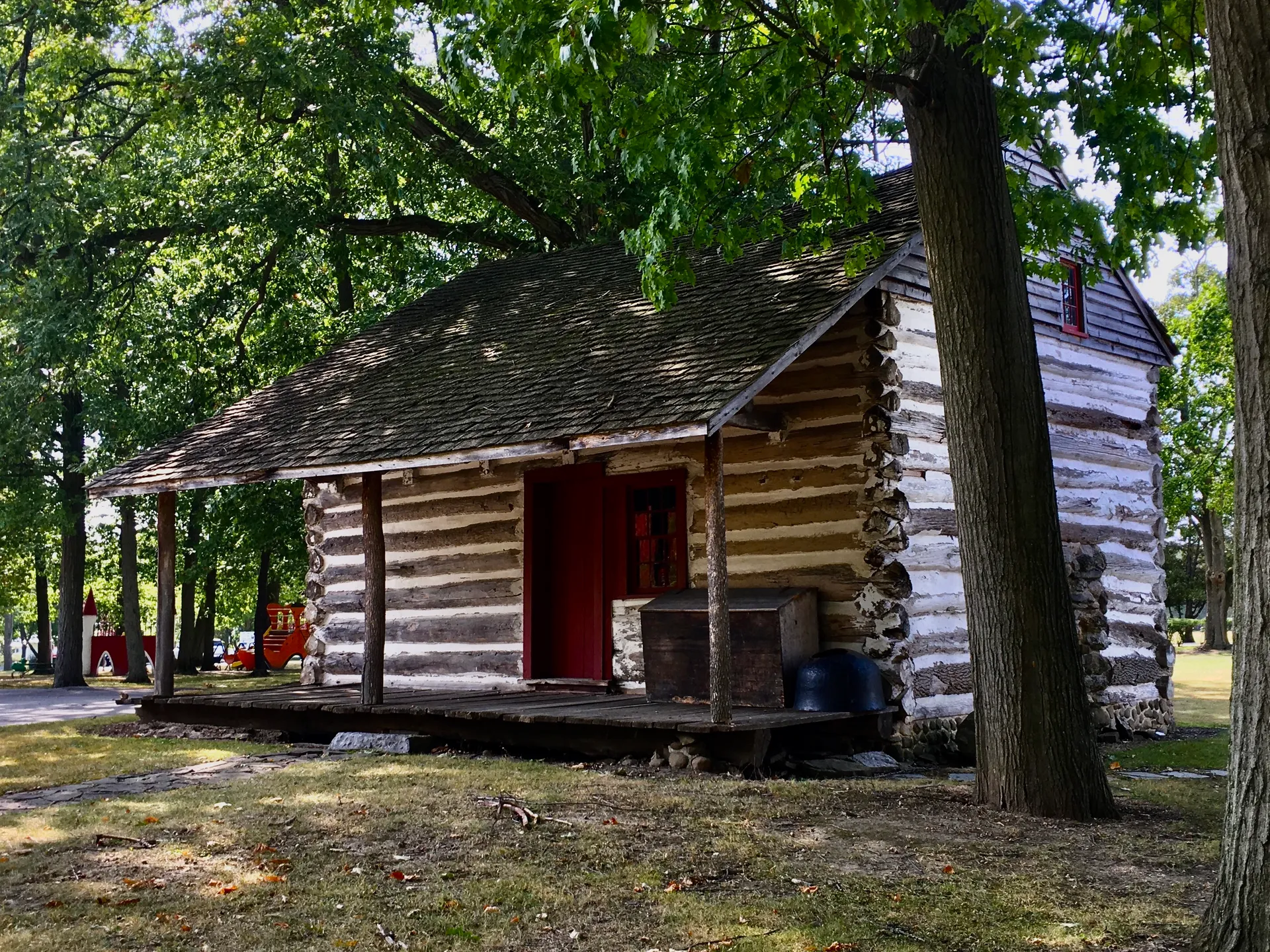 Historic Goodrich-Landow Log Cabin among trees in Clarence, New York.