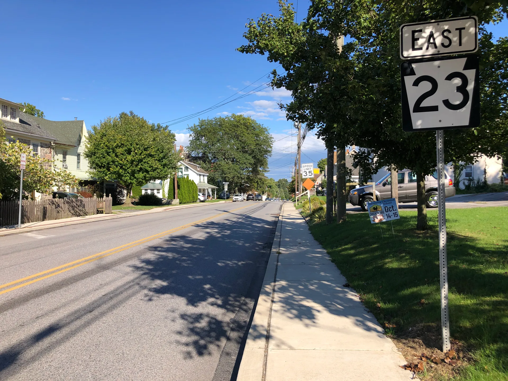 Main Street (Route 23) in Elverson runs east from Chestnut Street past homes, lawns and a shaded sidewalk.