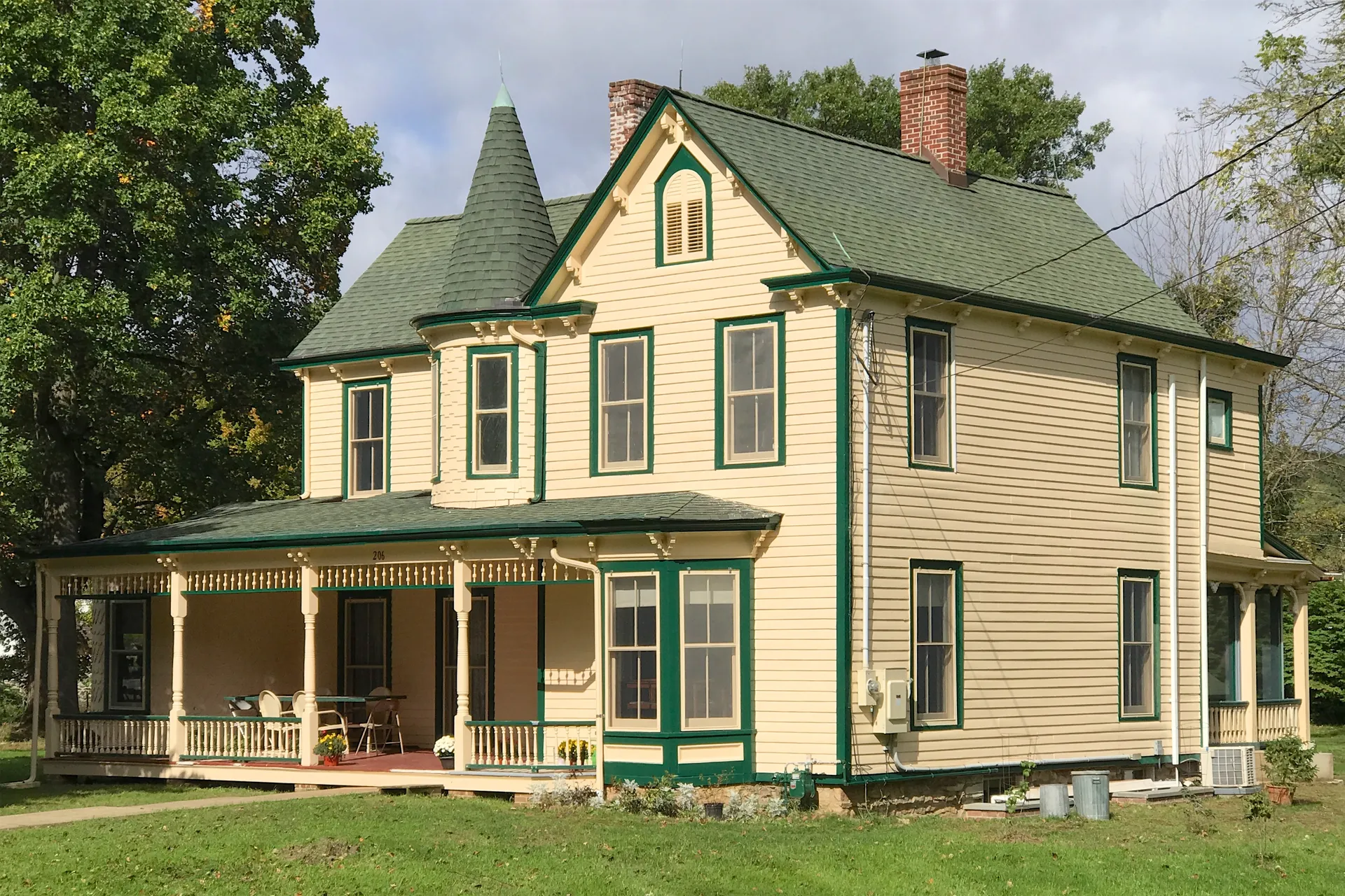The King Home at 209 Main Street in Ledgewood is a yellow Victorian house with green trim and a wraparound porch.