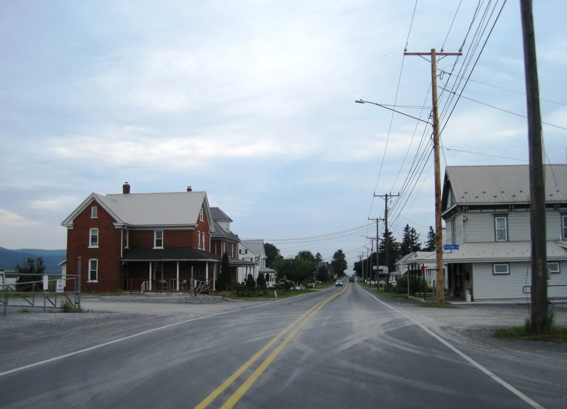 Curryville Road (Route 866) runs south through Curryville in North Woodbury Township, past a brick house with a porch.