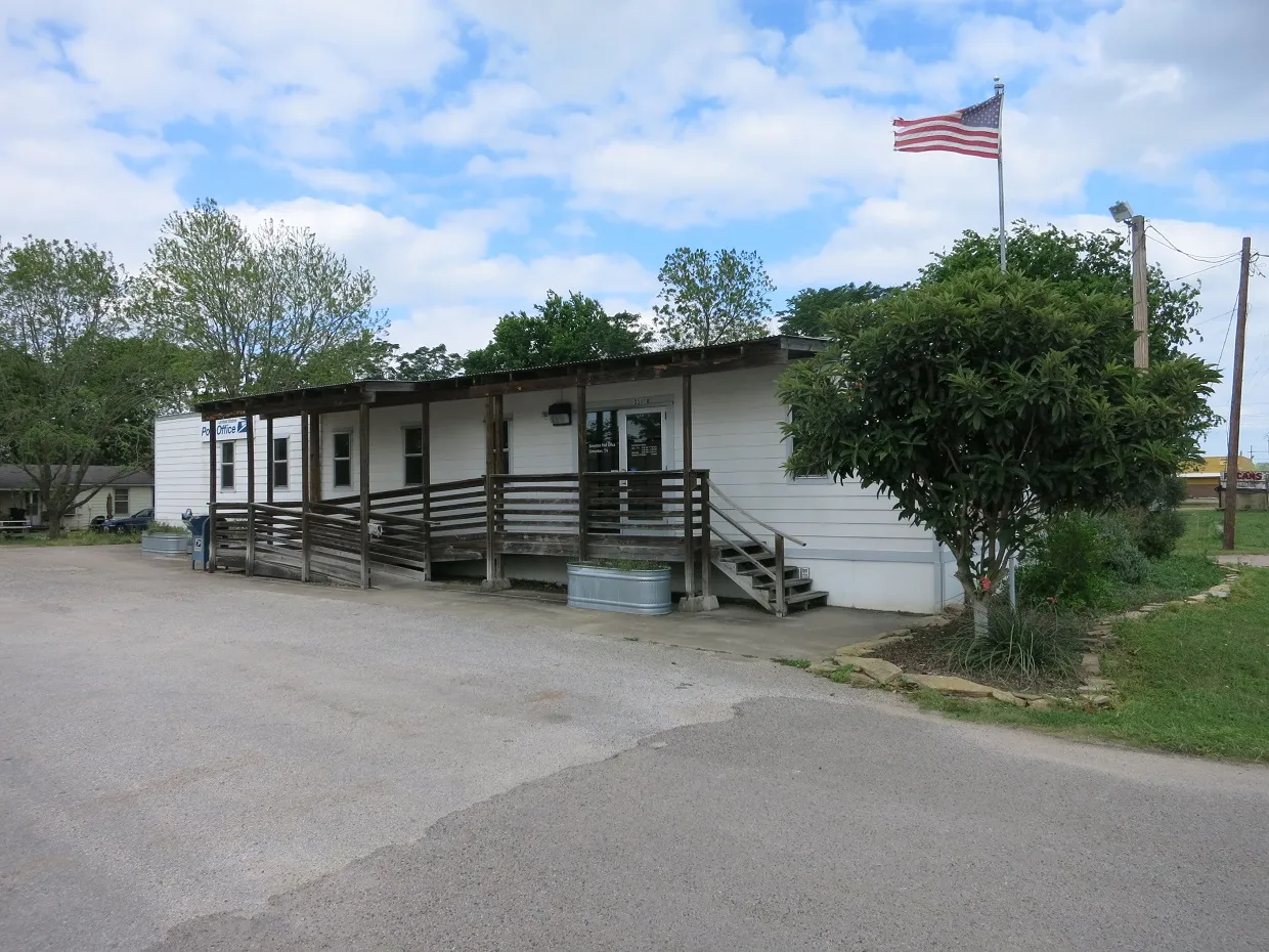 Small post office building with a flag in Simonton, Texas.