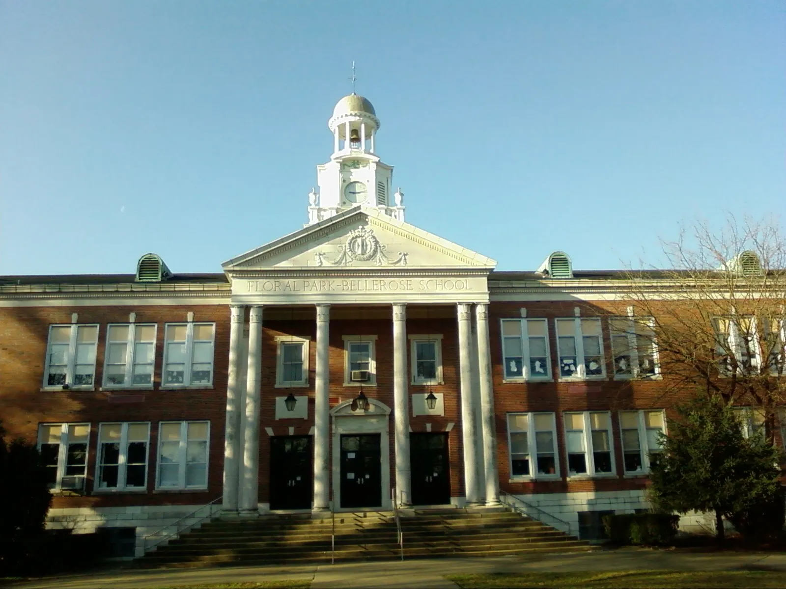 Historic brick Floral Park-Bellerose School with a white cupola in Floral Park, New York.