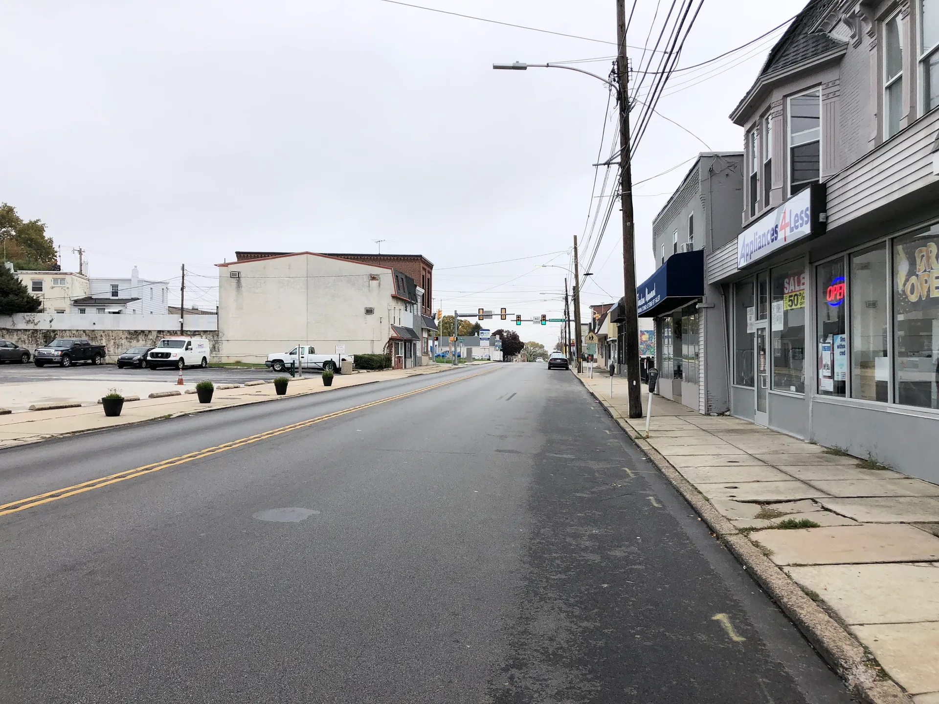 Baltimore Avenue climbs northeast from Springfield Road in Clifton Heights, lined with brick commercial buildings and storefront awnings.