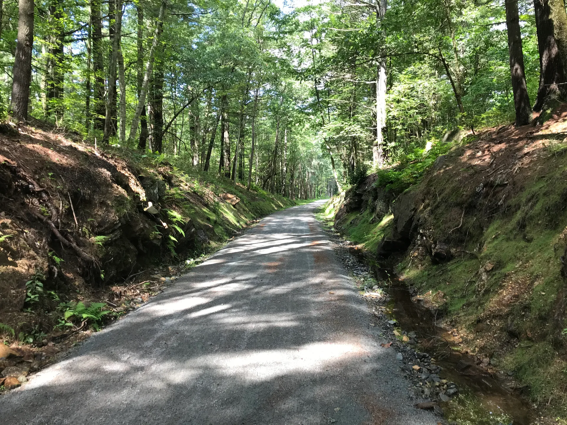 Squannacook River Rail Trail through a wooded cut in Townsend, Massachusetts.