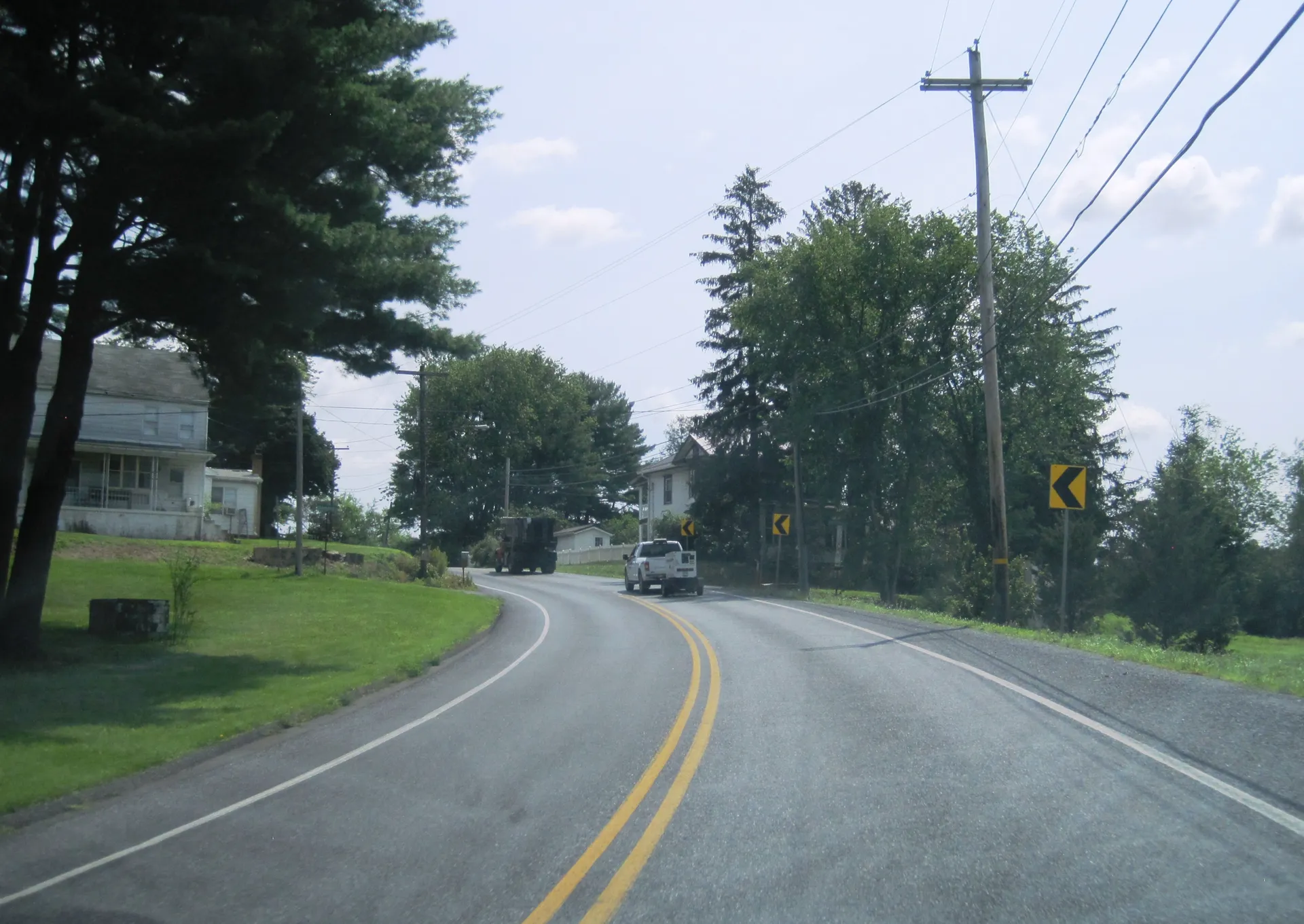 U.S. Route 209 bends through Steins, a small village in Branch Township, with lawns, evergreens and a house tucked among trees.